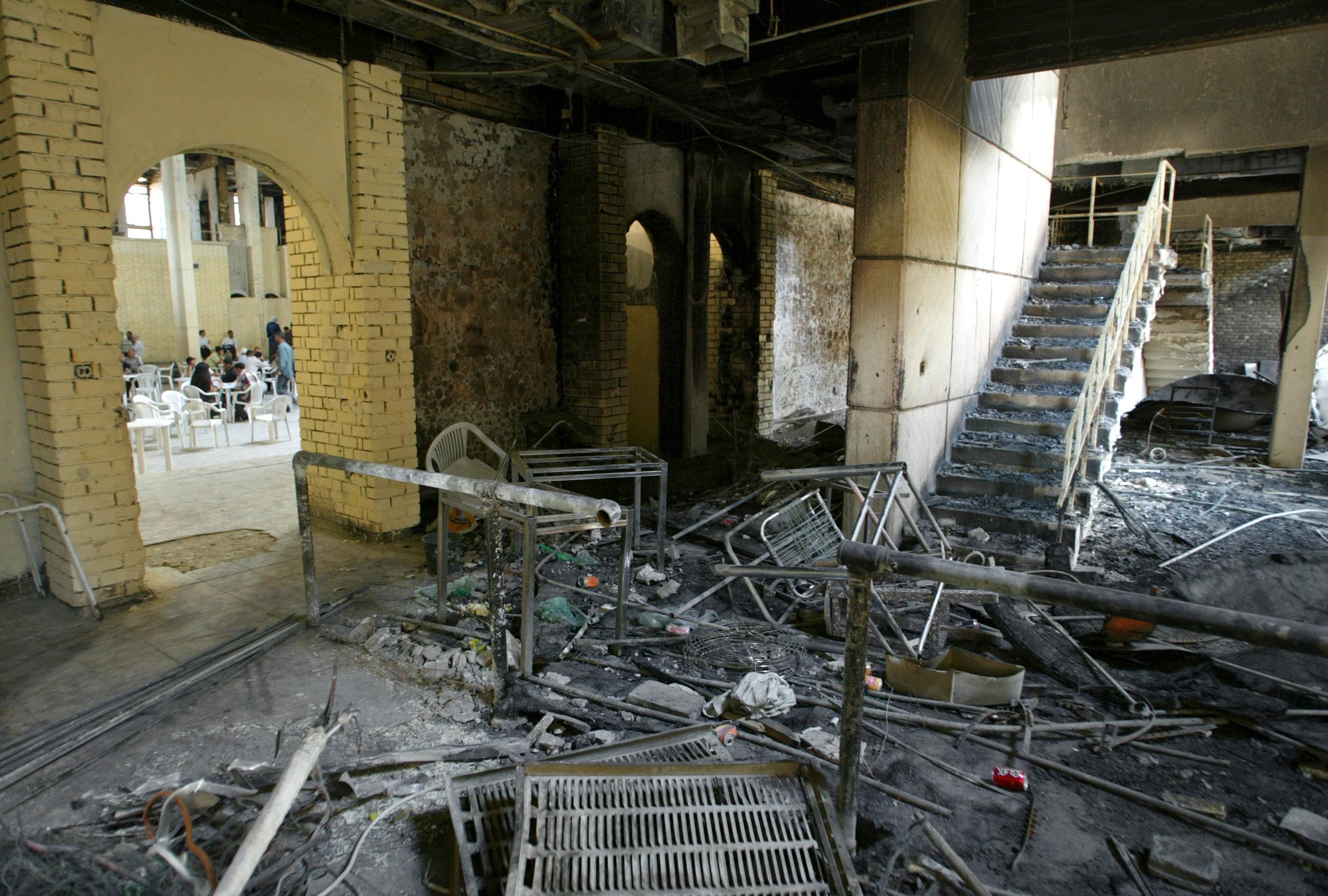Iraqi students sit in the cafeteria in the burnt out Baghdad University