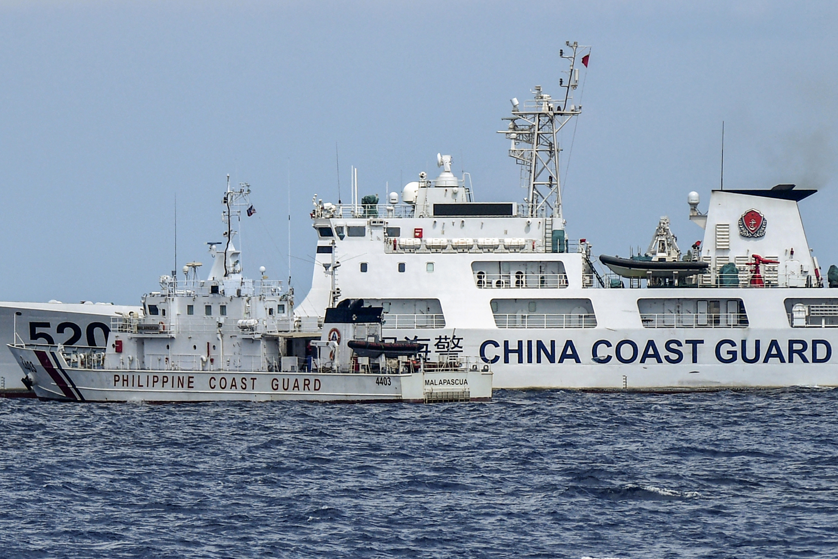 A Philippine coast guard vessel in a near collision with a Chinese coast guard ship in the South China Sea. Both vessels are clearly marked. The Chinese ship is far bigger than the Philippines one and cutting into its path.