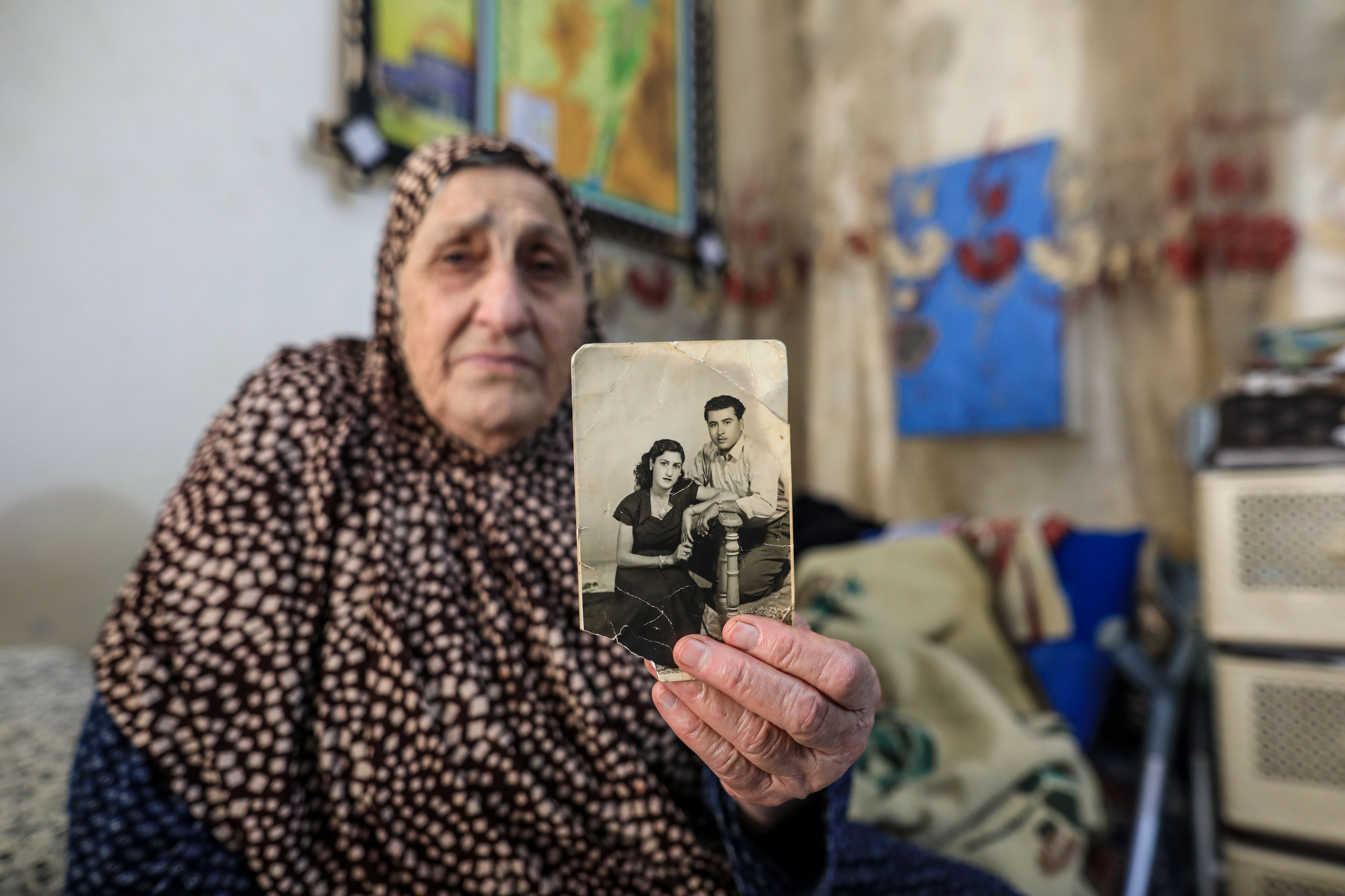 An elderly woman holds a photo