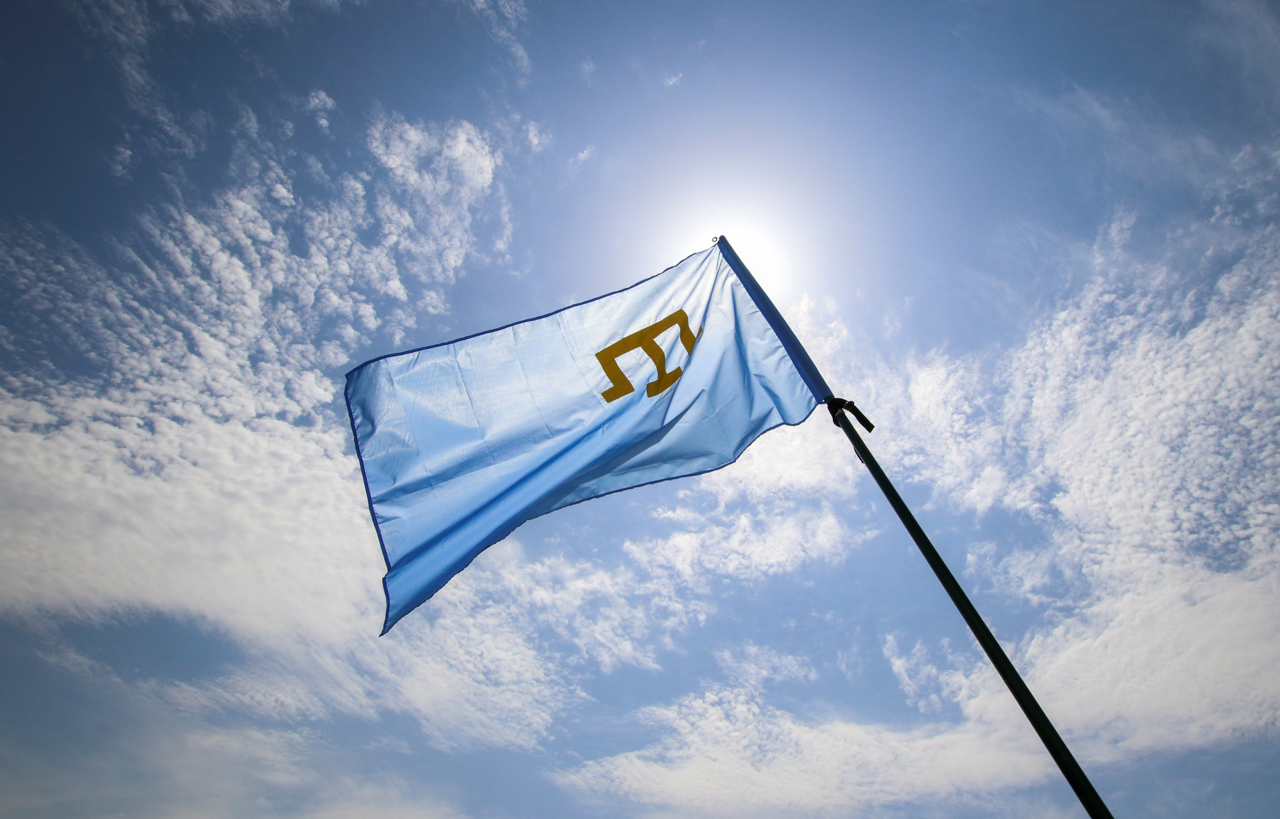 A Crimean Tatars flag flies at a rally, commemorating Crimean Tatars mass deportations from the region in 1944, in the village of Siren, in Bakhchisaray district, Crimea, May 18, 2019. REUTERS/Alexey Pavlishak
