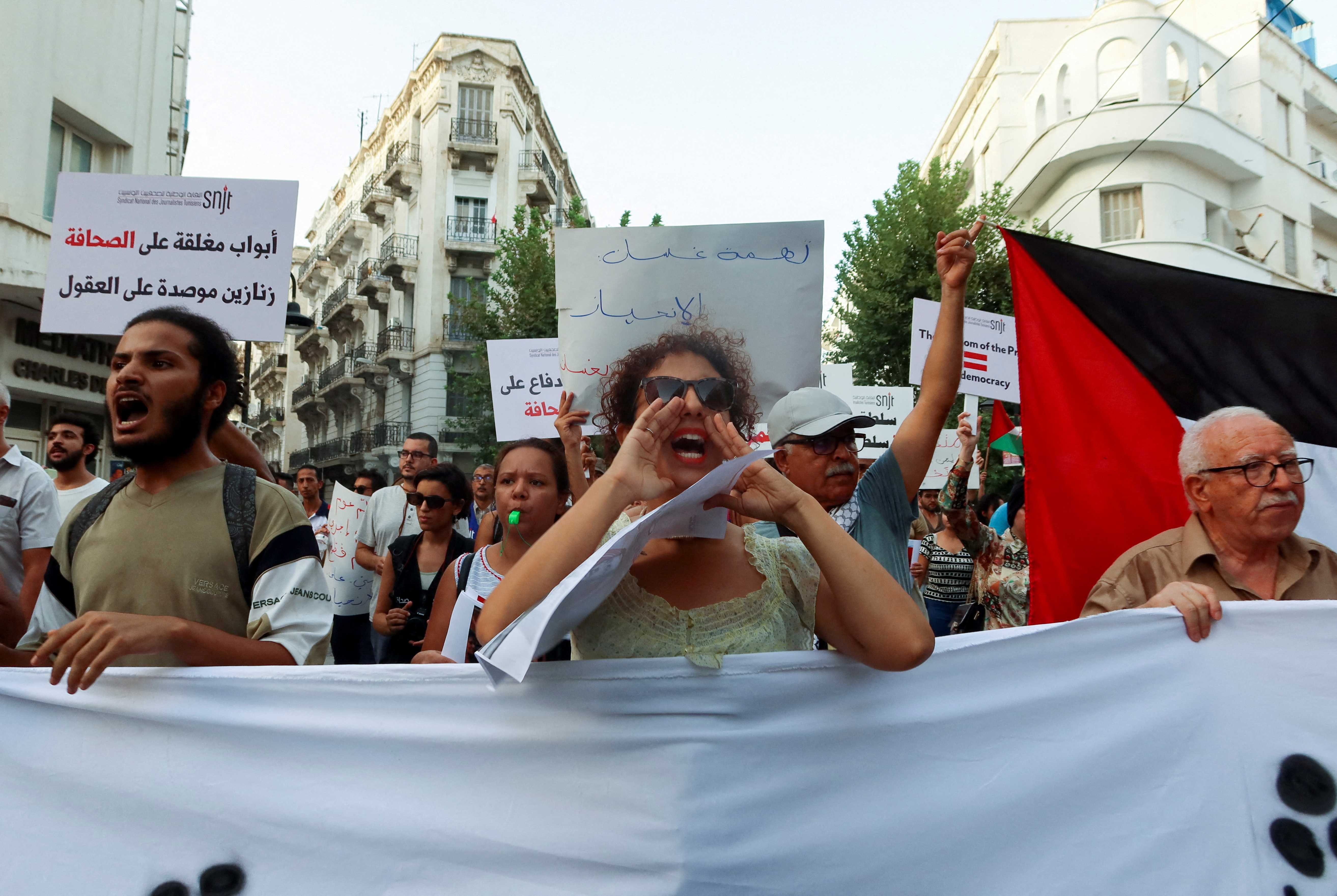 Demonstrators carry banners during a protest organized by the National Union of Tunisian Journalists, September 9, 2022