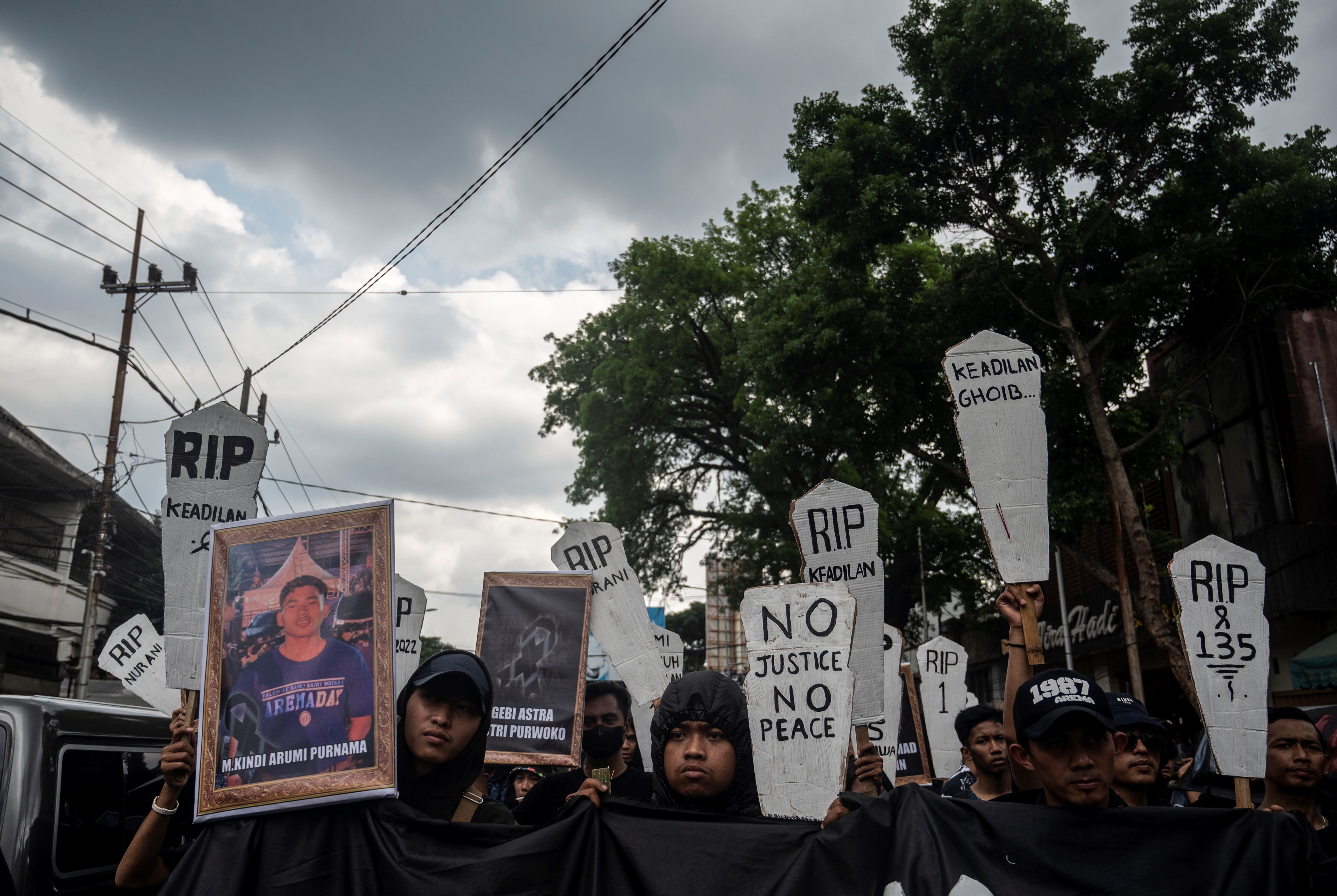 People carry mock gravestones in a protest over the deaths at the Kanjuruhan stadium Some read 'No Justice, No Peace'