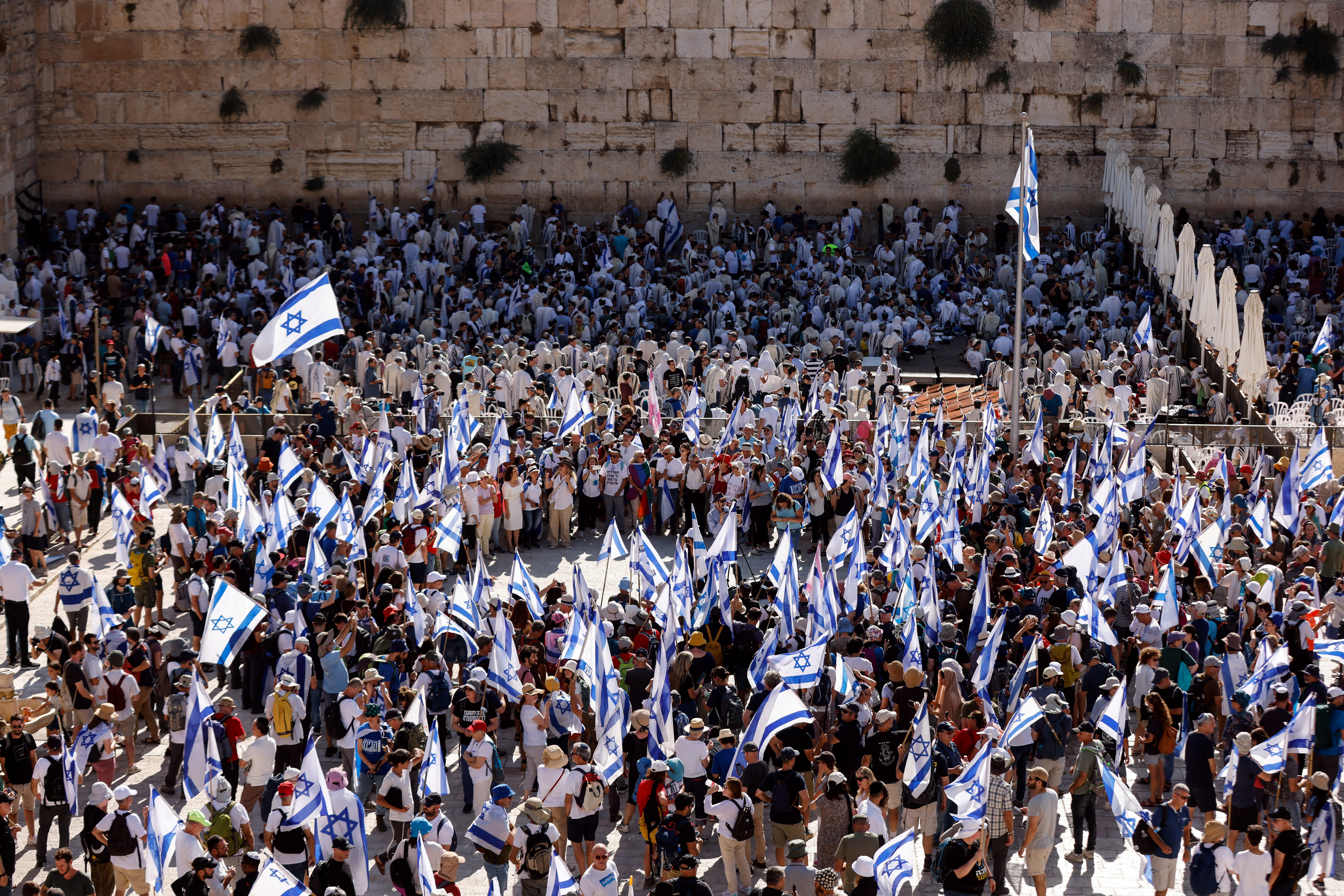 Protesters hold Israeli flags as they attend a gathering on a day of planned mass demonstrations against Israeli Prime Minister Benjamin Netanyahu and his nationalist coalition government's judicial overhaul, near the Western Wall, Judaism's holiest prayer site in Jerusalem