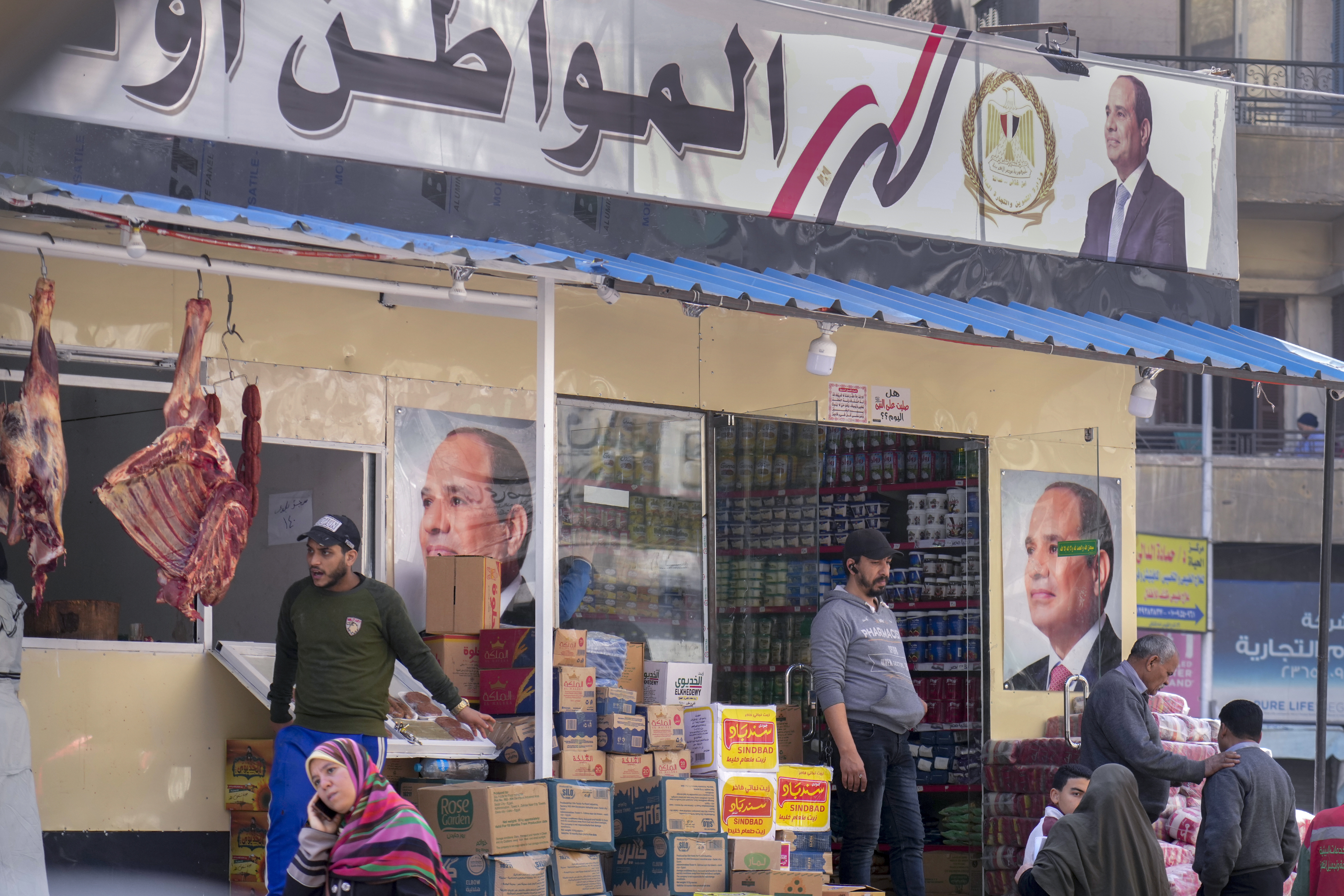 Clients buy groceries at a government sponsored shop fronted with Egyptian President Abdel Fattah el-Sissi posters in Cairo, Egypt, Feb 27, 2023