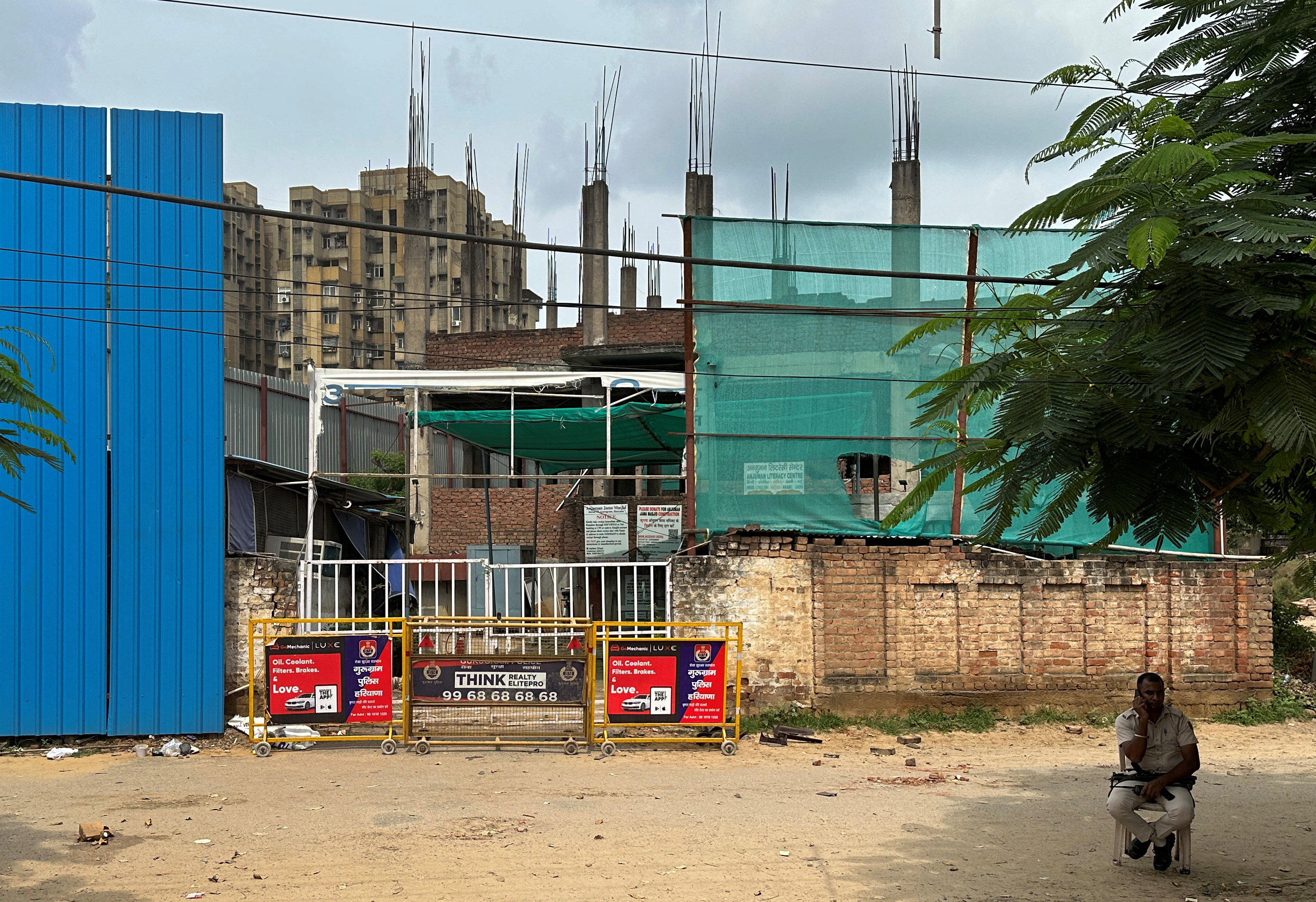 A police officer sits outside a mosque that was attacked by a mob