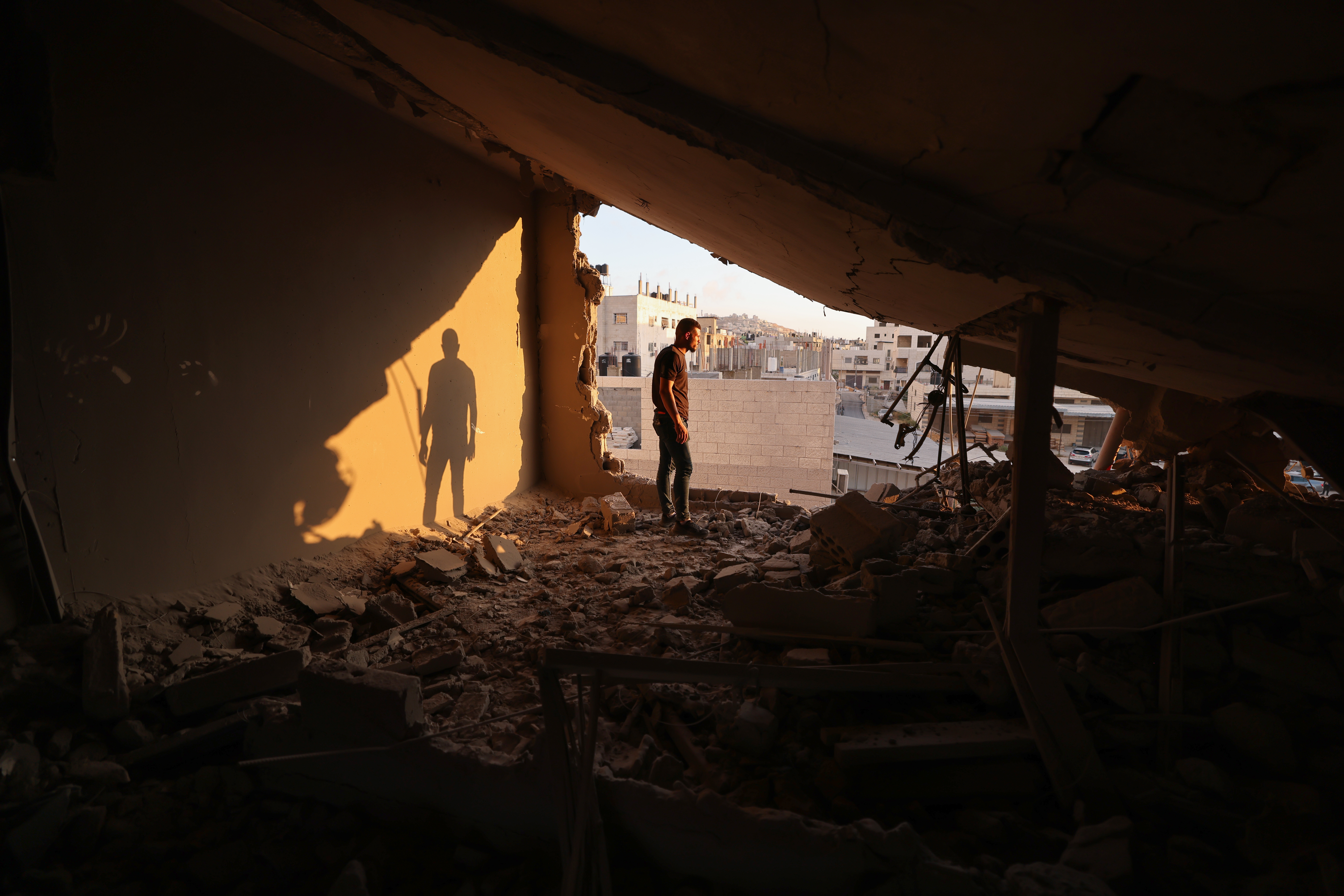 A man inspects the remains of a house which Israeli soldiers demolished at the Asker camp