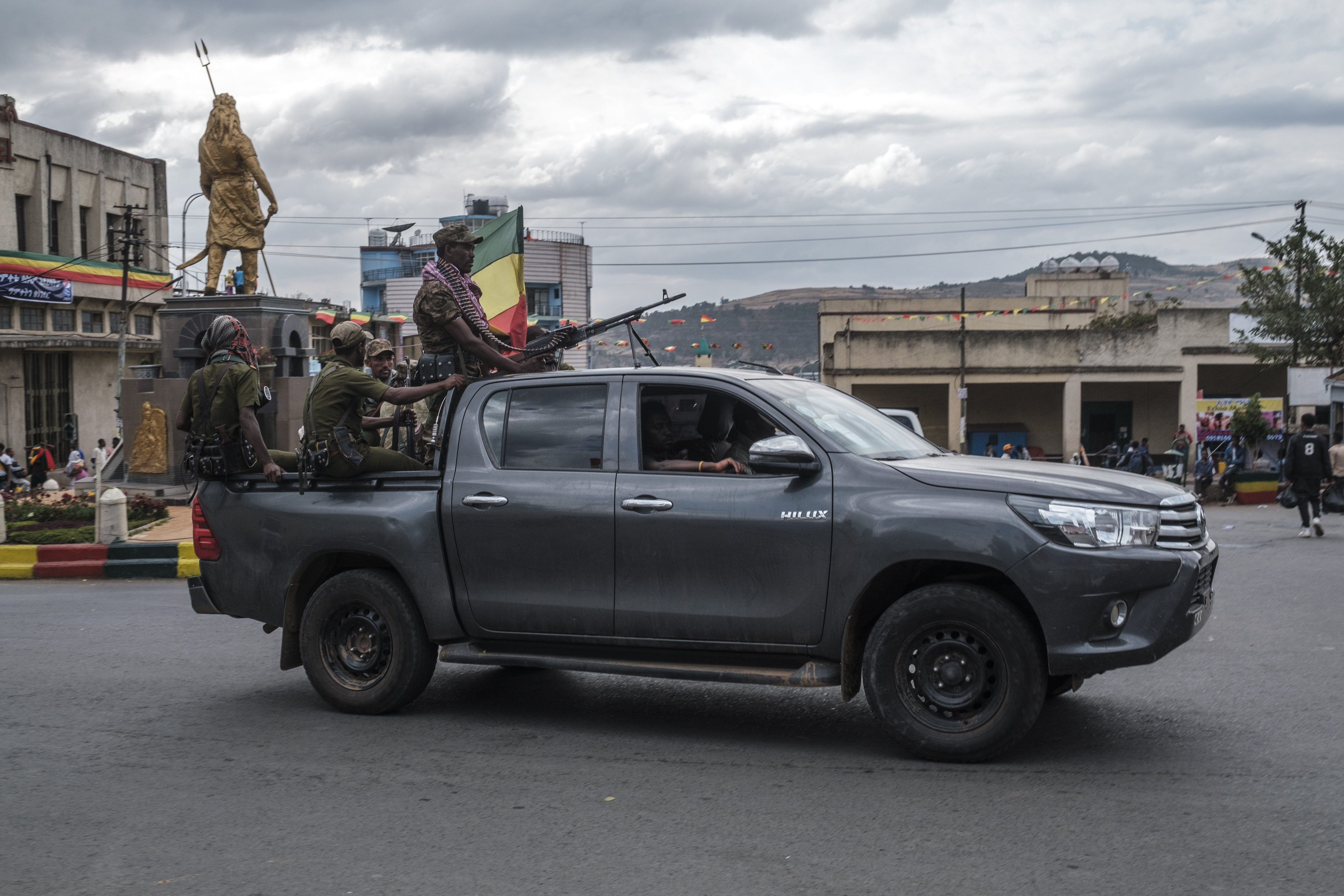 Members of the Amhara militia ride in the back of a pick up truck in the city of Gondar