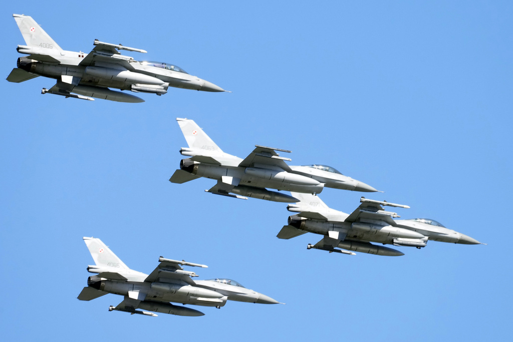 U.S.-made F-16 fighter jets fly in the sky over Poland's capital as they take part in a massive military parade to celebrate the Polish Army Day, commemorating the 1920 battle in which Polish troops defeated advancing Bolshevik forces, in Warsaw, Poland, Tuesday, Aug. 15, 2023. Poland is holding a military parade to showcase its state-of-the-art weapons and defense systems, as war rages across its southeastern border in neighboring Ukraine and ahead of parliamentary elections scheduled for Oct. 15. (AP Photo/Czarek Sokolowski)