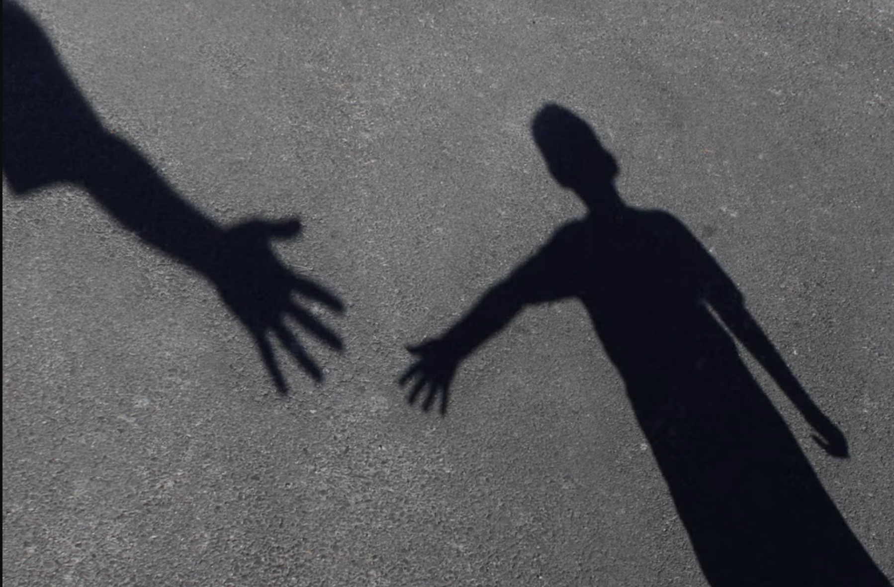 Shadows of man and child reach towards each other