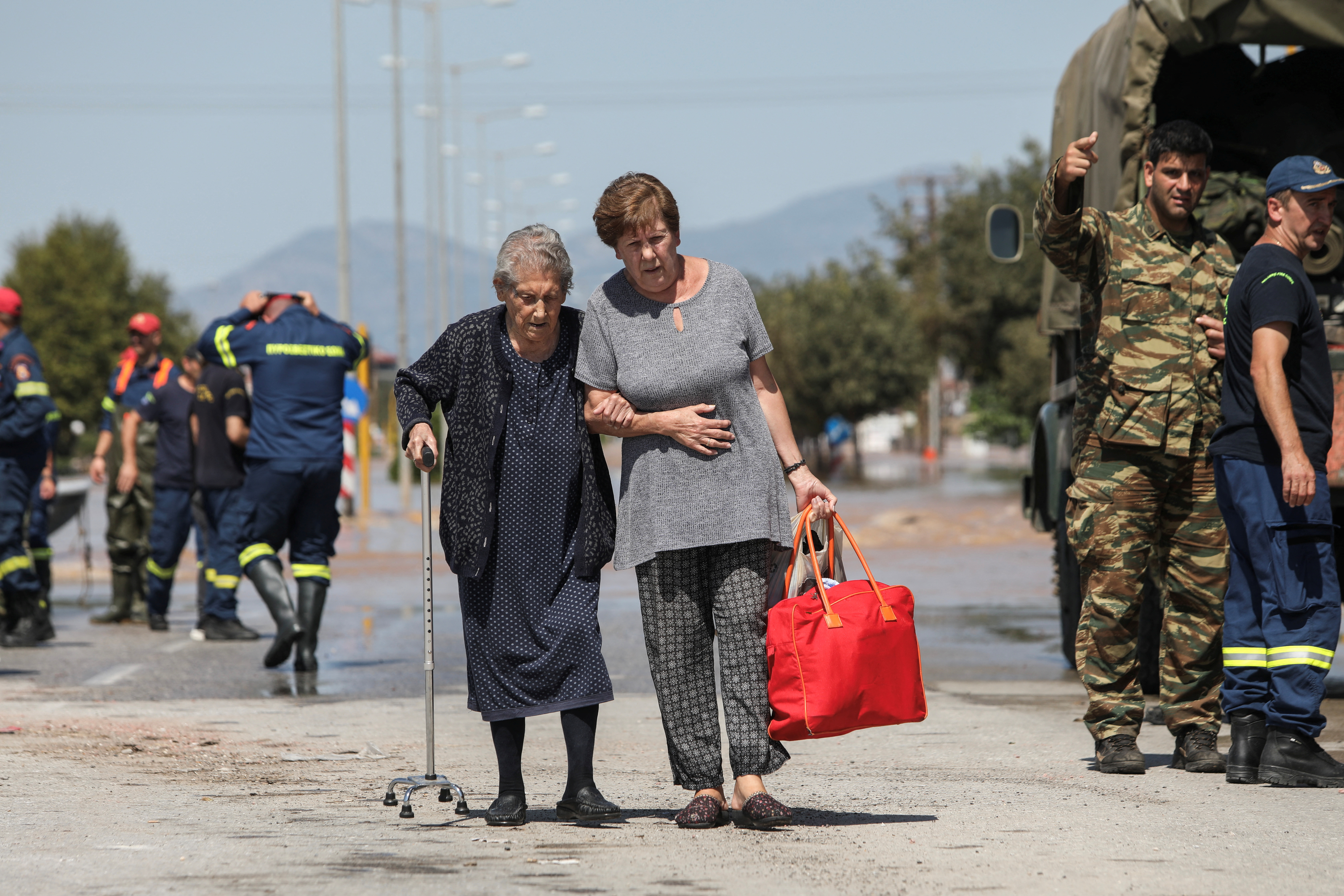 Two women leave a flooded area after being evacuated in the aftermath of Storm Daniel in Larissa, Greece [Elias Marcou/Reuters]