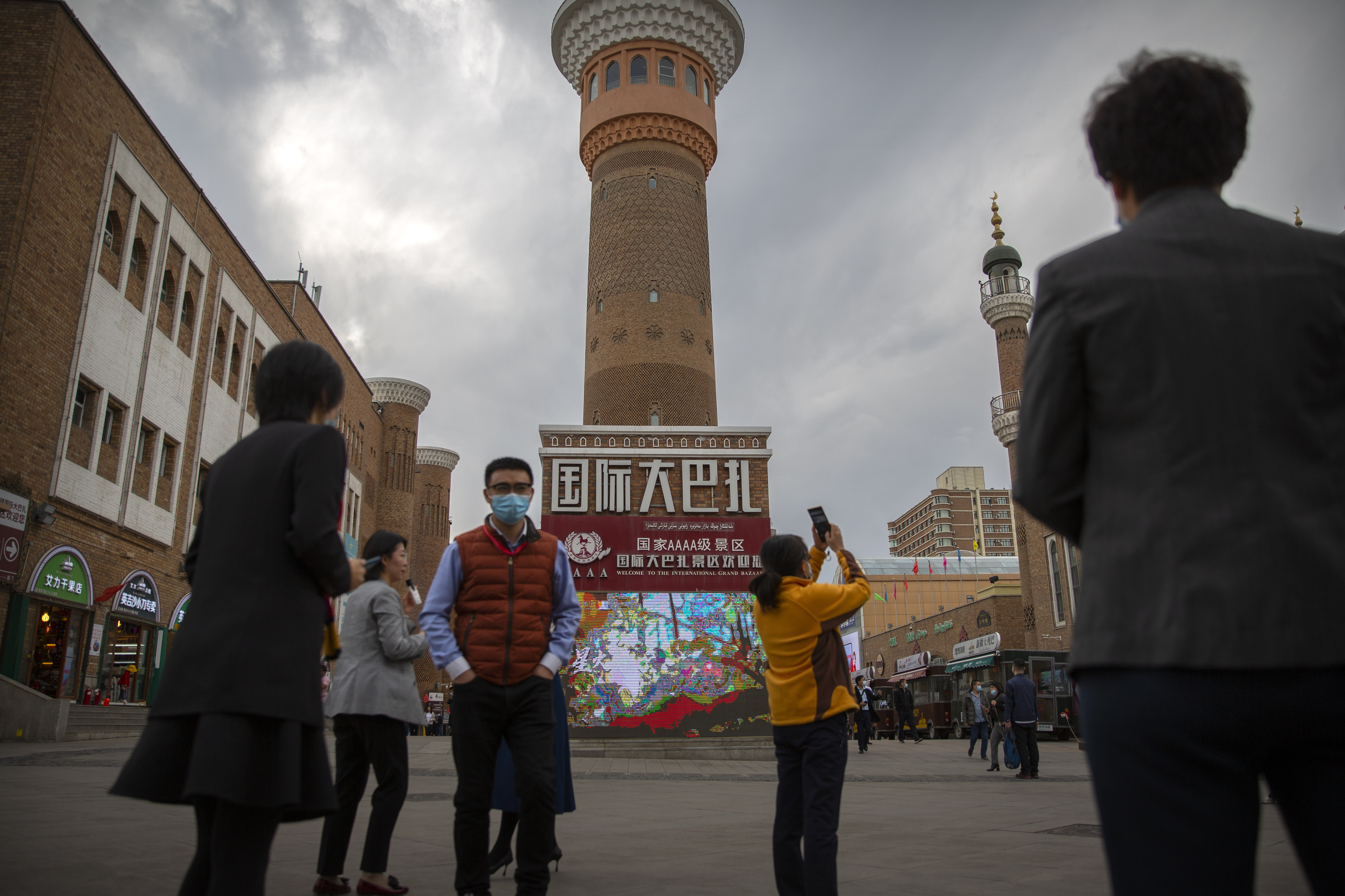 Tourists take photos near a tower at the International Grand Bazaar in Urumqi in western China's Xinjiang