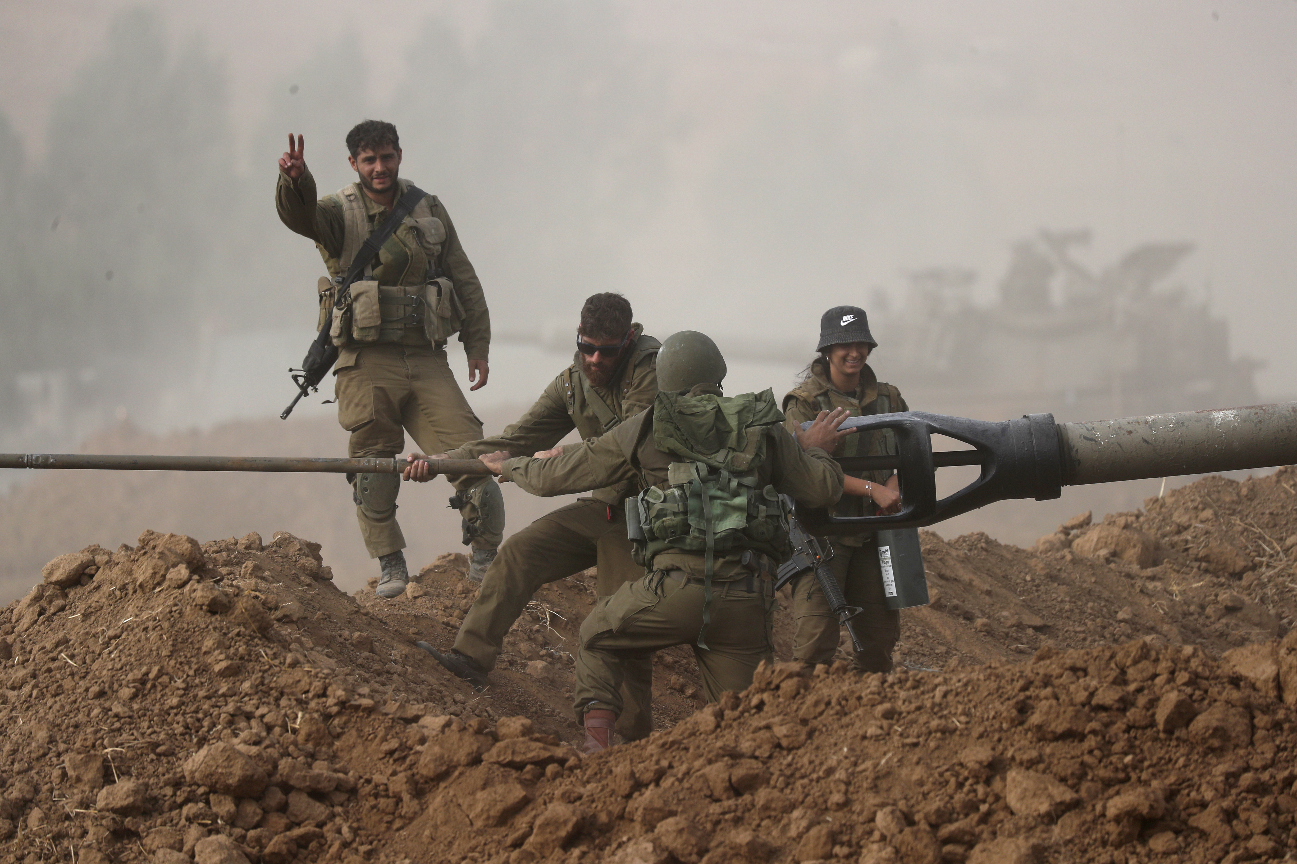 Israeli artillery soldiers clean a cannon at an area along along the border with Gaza