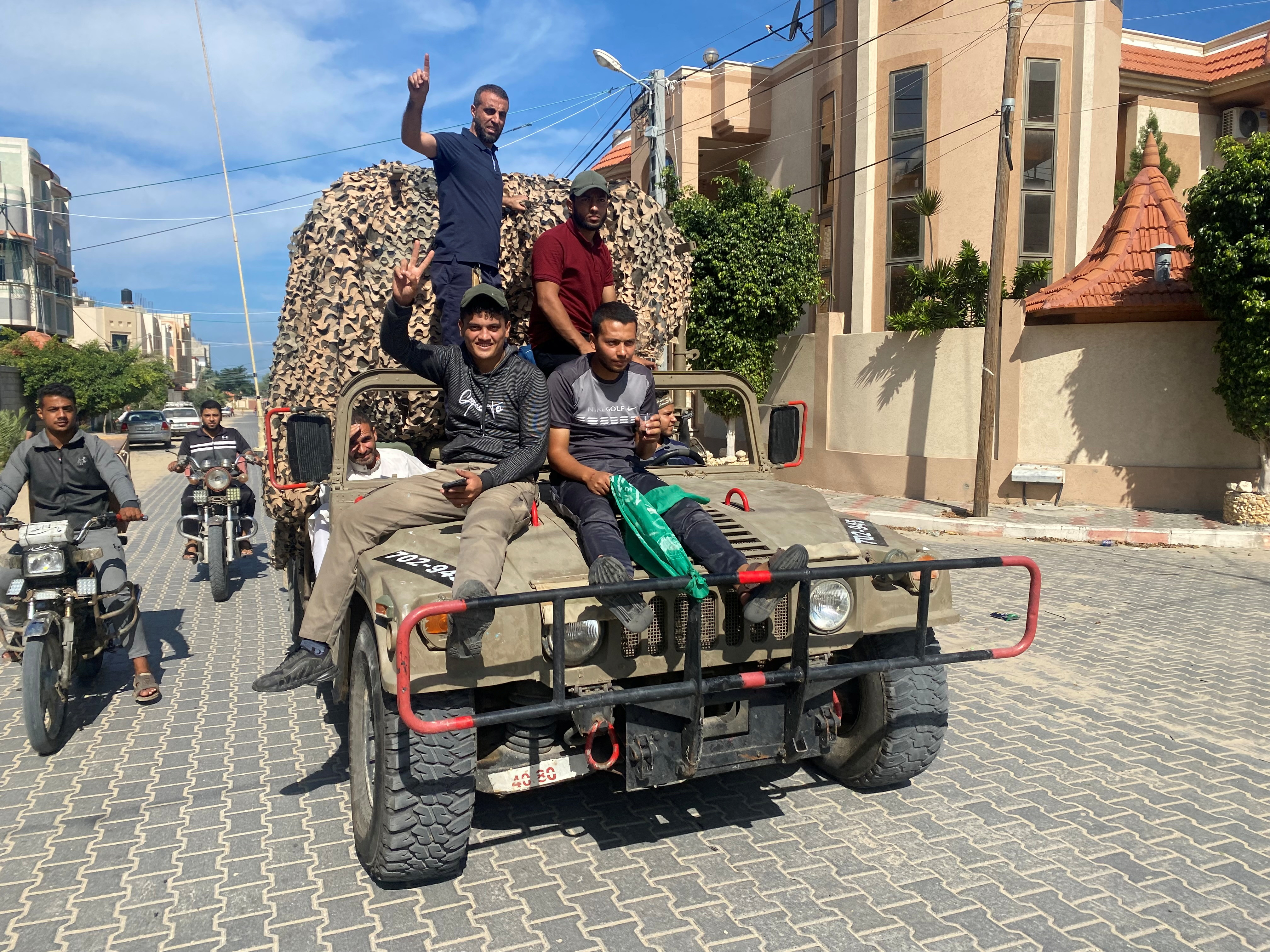 Palestinians ride on an Israeli military vehicle seized by Palestinian gunmen who infiltrated areas of southern Israel, in the southern Gaza Strip.
