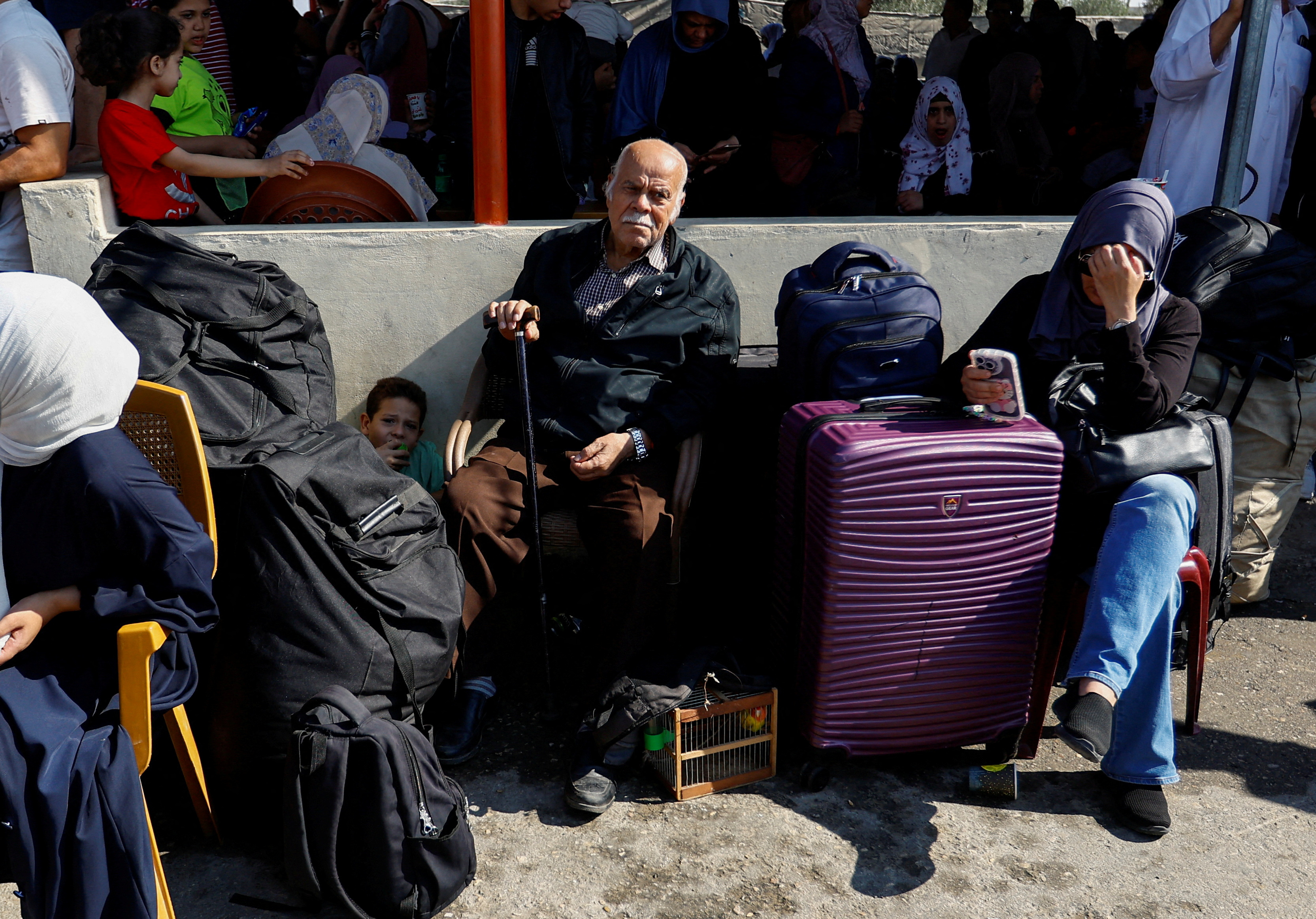 Palestinians with dual citizenship gather outside Rafah border crossing with Egypt in the hope of getting permission to leave Gaza