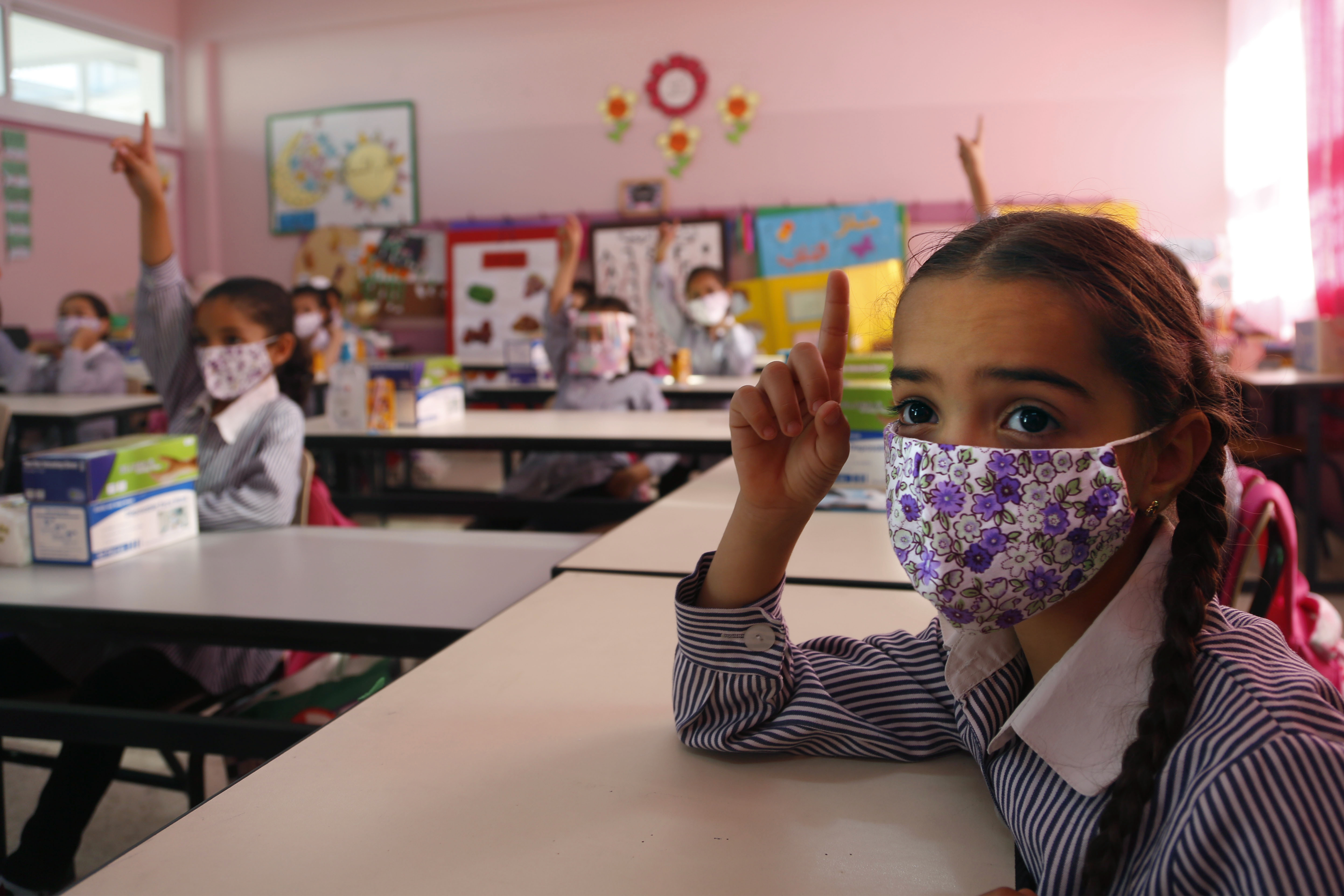 Palestinians elementary school students wearing protective face masks, gesture in their classroom amid the coronavirus pandemic on the first day of class at United Nations-run school in the West Bank city of Ramallah, Sunday, Sept. 6, 2020.(AP Photo/Majdi Mohammed)