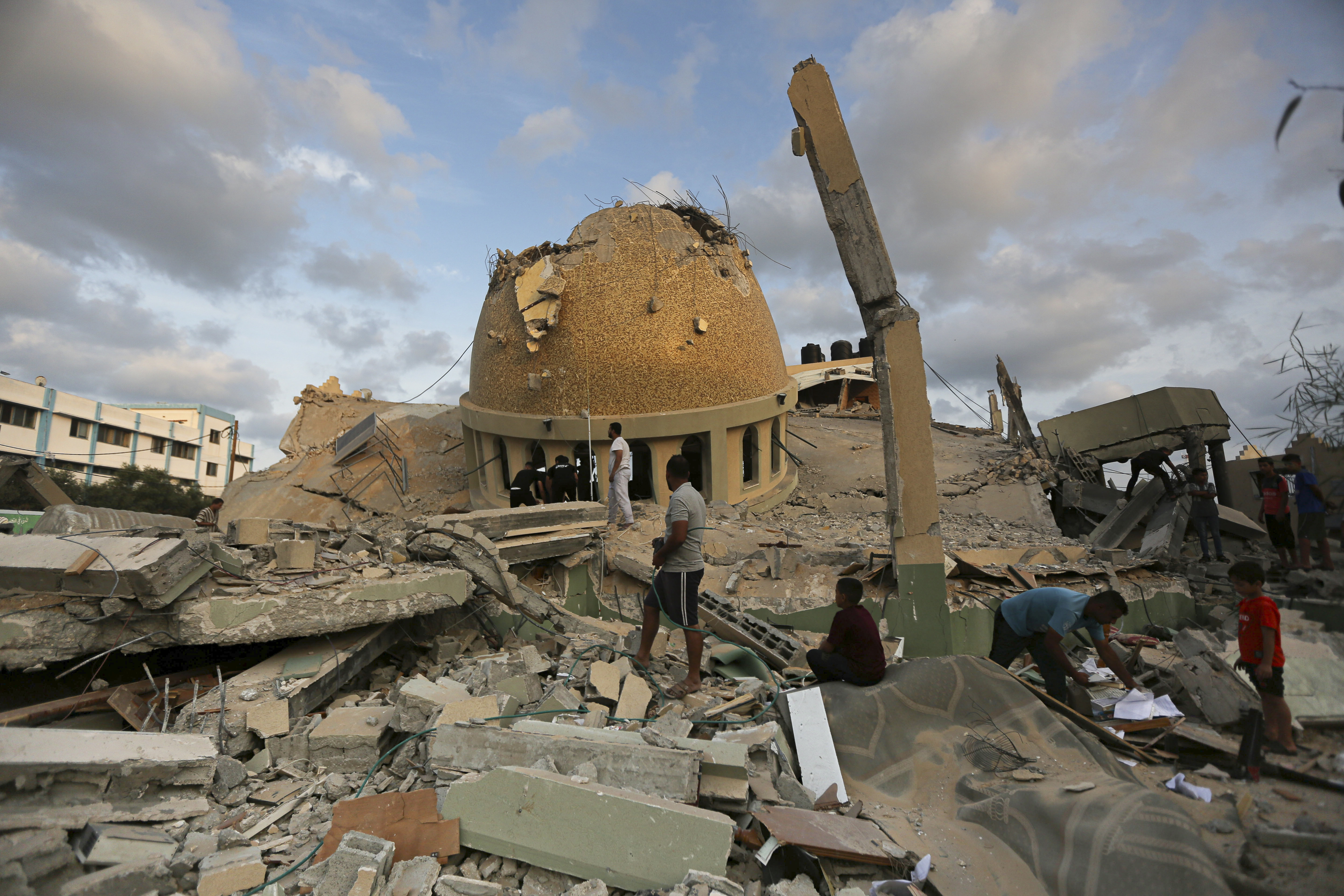 A man takes a solar panel from a mosque destroyed in an Israeli air strike in Khan Younis