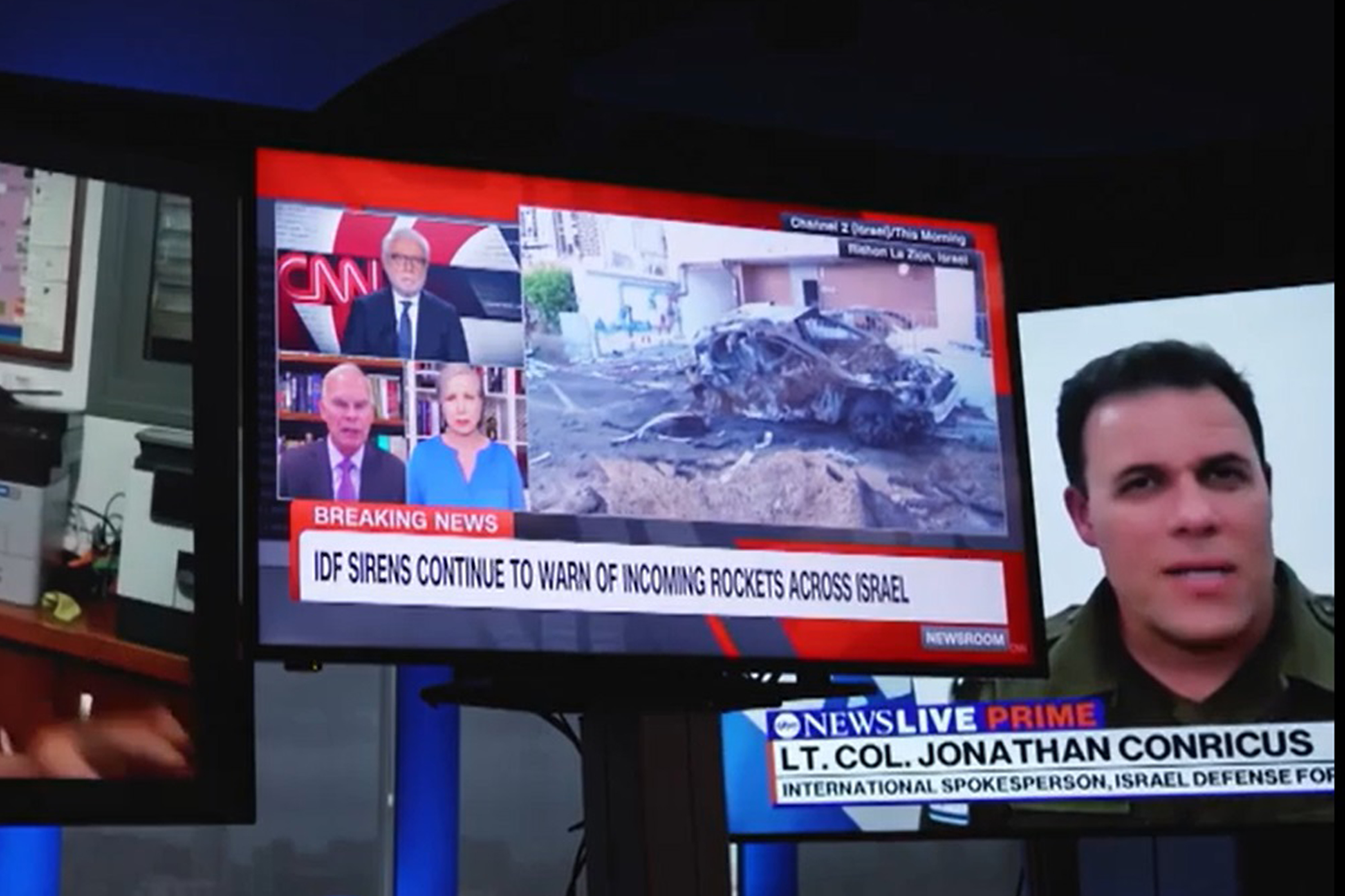 A photo of TV screens with CNN and NBC on them