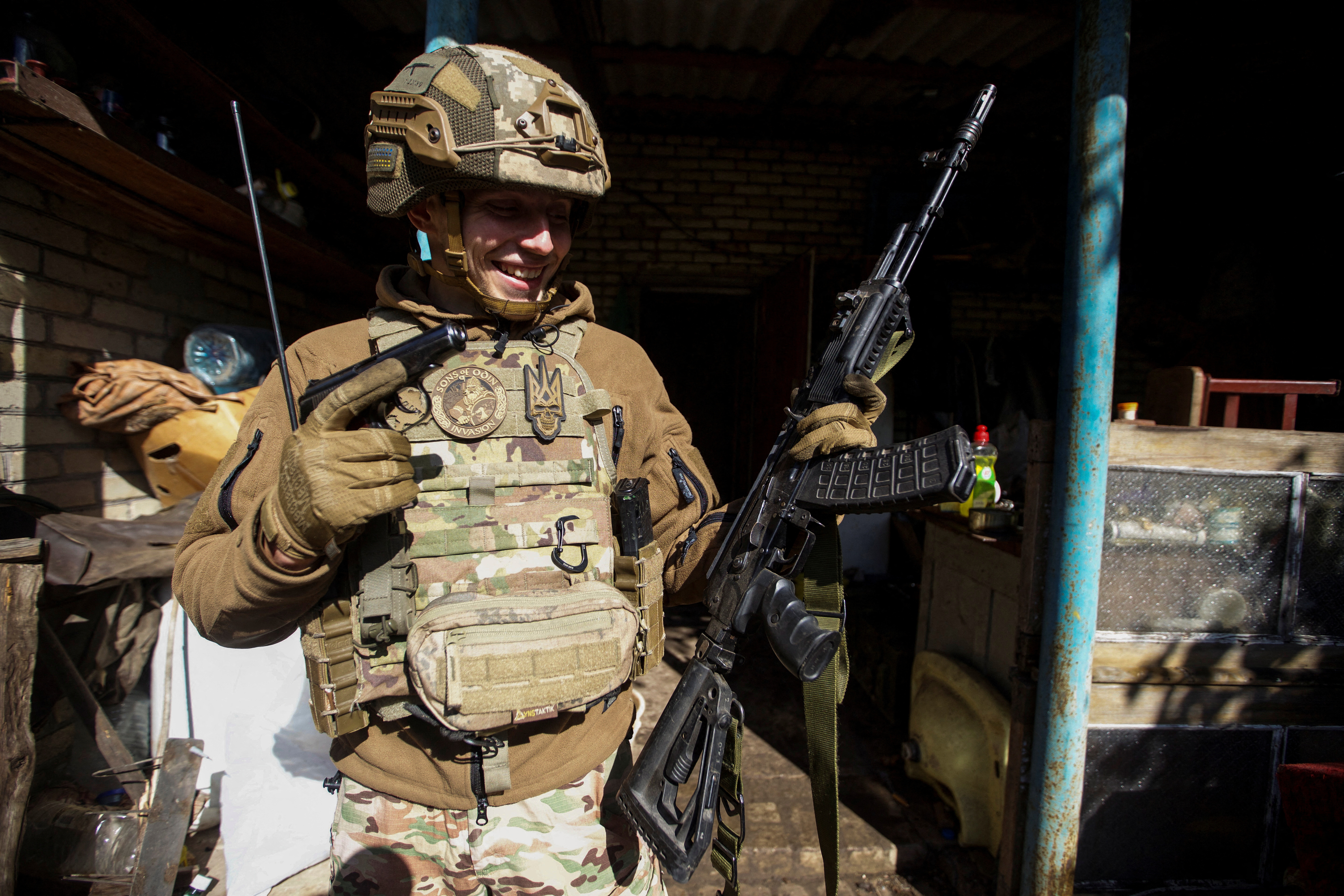 A Ukrainian service member holds captured Russian weapons, amid Russia's attack on Ukraine