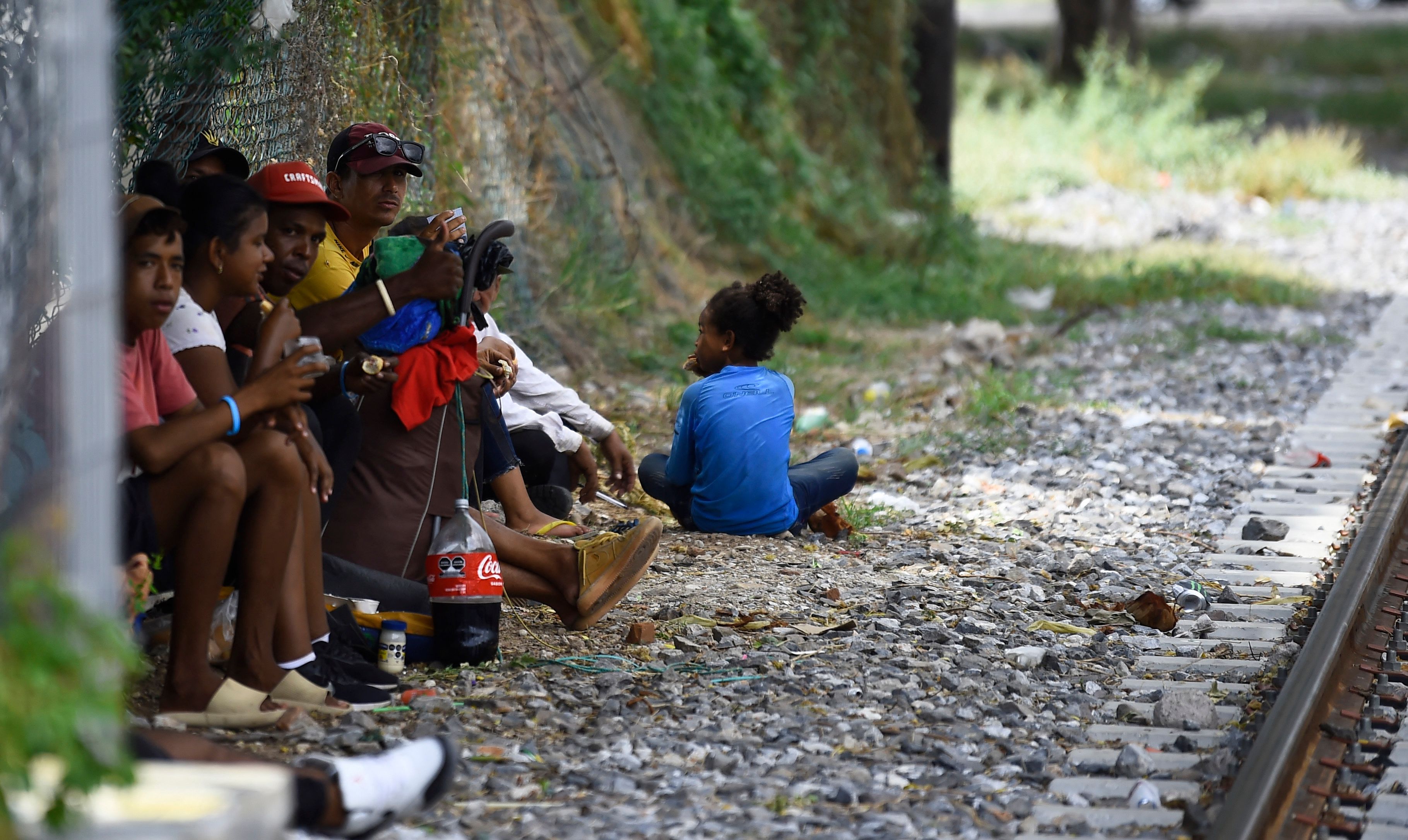 People in transit rest near a train station in Ixtepec, the Isthmus of Tehuantepec, Oaxaca, Mexico on October 10, 2023 [Claudio Cruz/AFP]