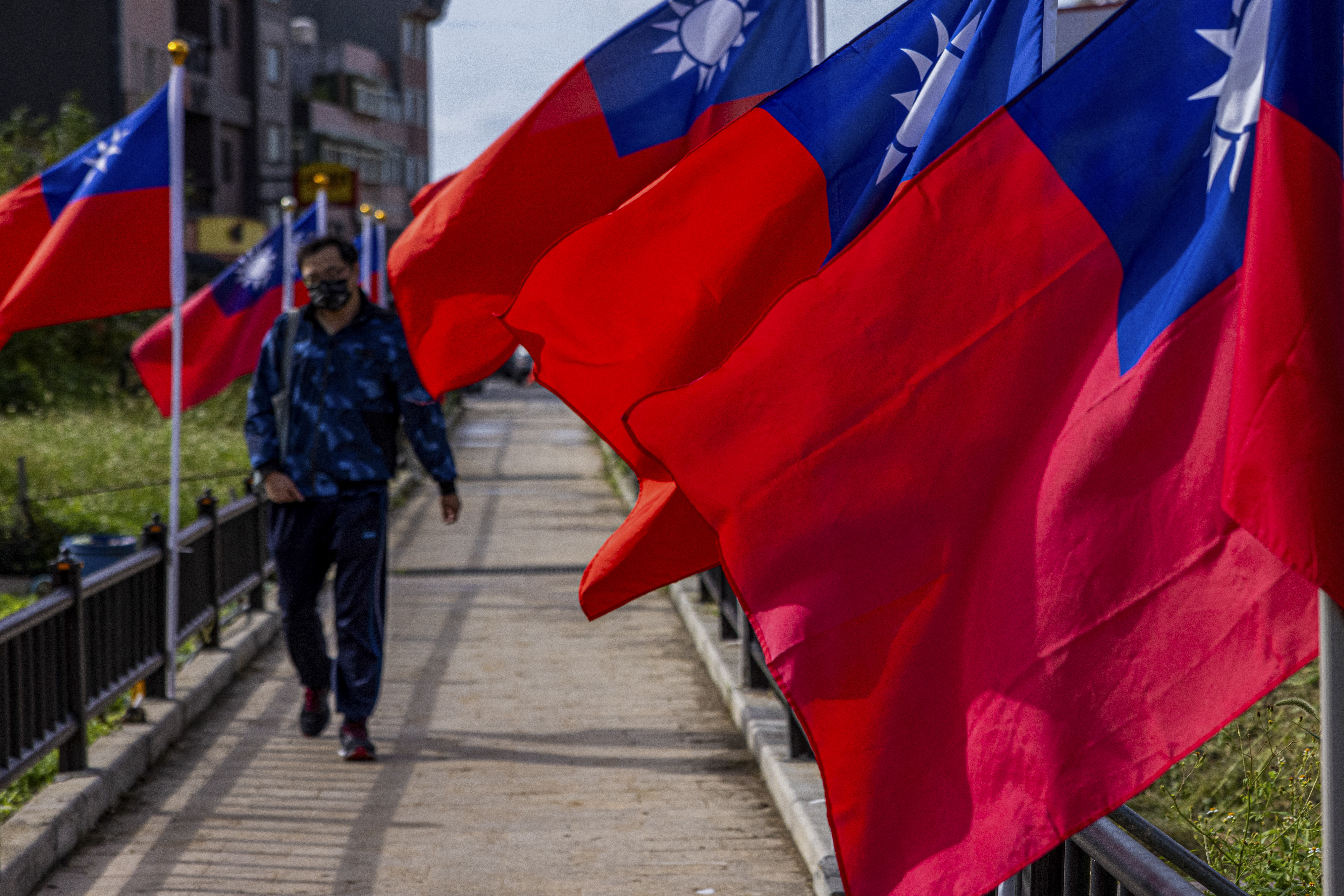 A man walking past the flags of Taiwan