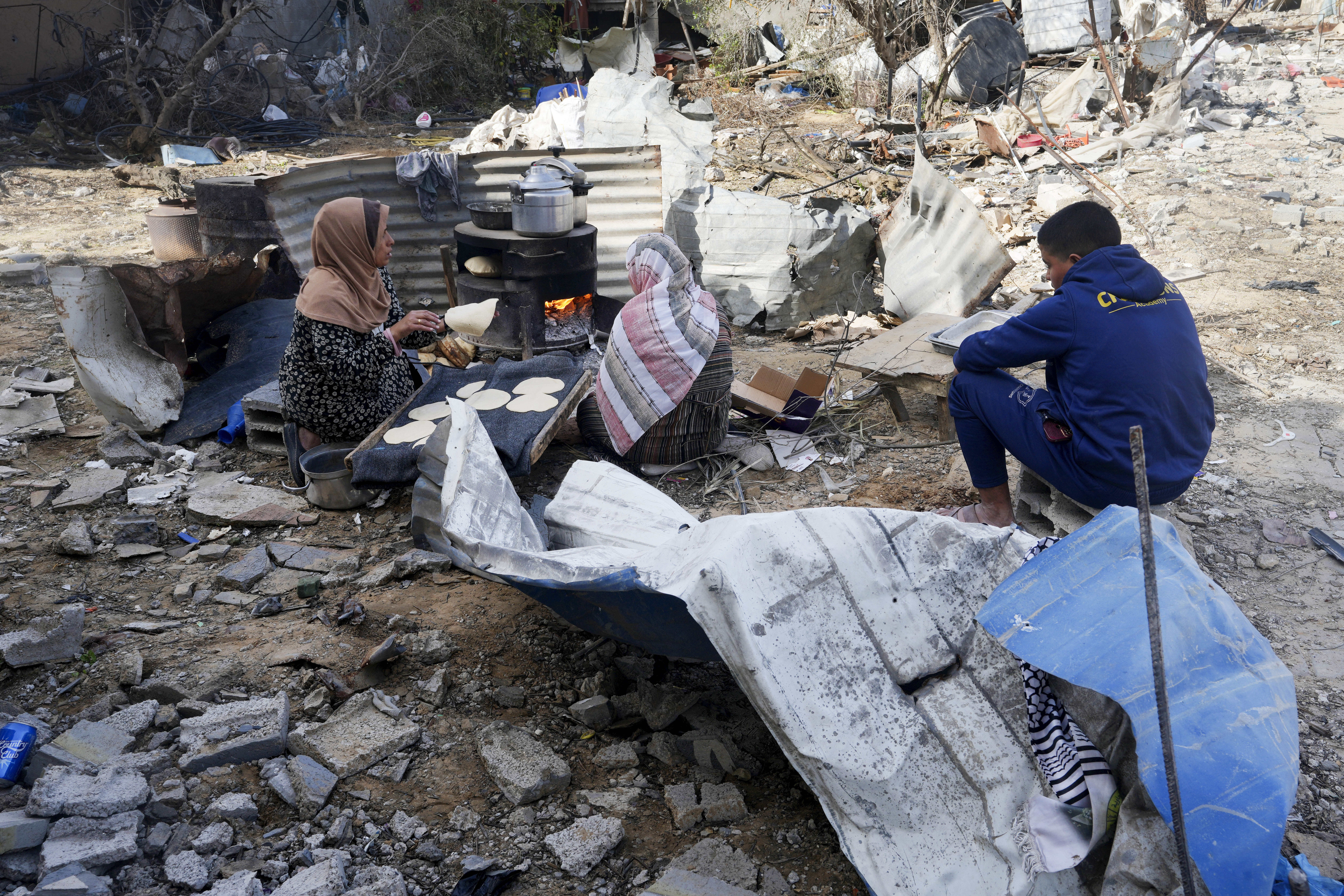 Women in Gaza must improvise when it comes to cooking for their families ever since the Israeli bombardment and total blockade of the strip began on October 7 [Adel Hana/AP]
