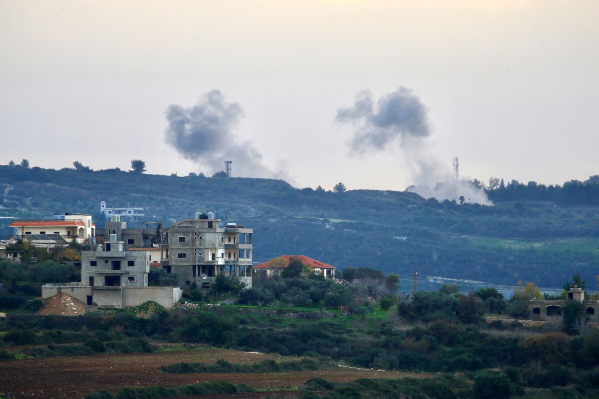 The view from the southern Lebanese village of Dhayra along the Israeli border shows buildings in the Lebanese town of Tair Harfa as smoke billows over northern Israel, on January 5, 2024 [AFP]