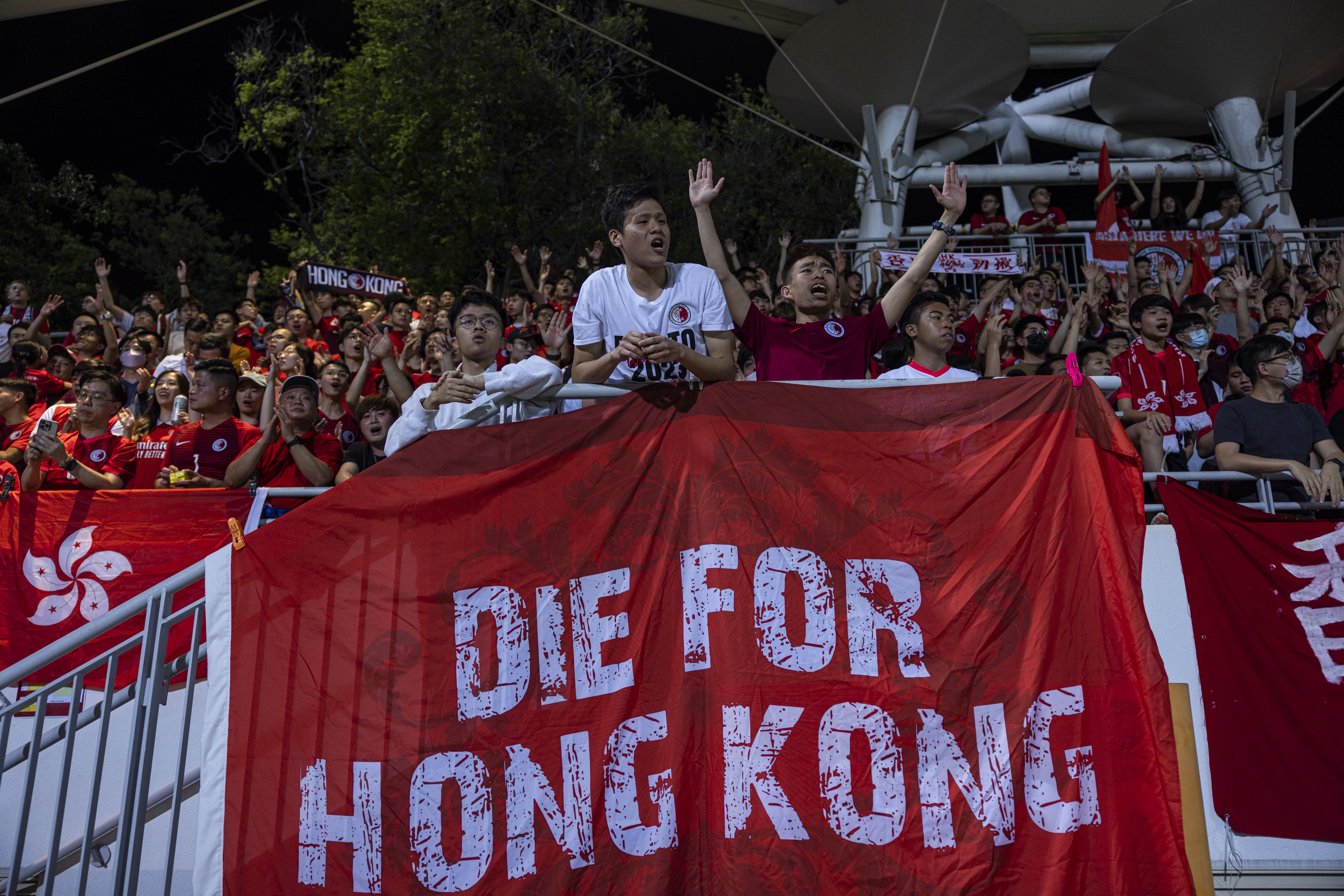 Supporters react during an international football friendly match between Hong Kong and Singapore at Mongkok Stadium in Hong Kong on Thursday, March 23, 2023 [Louise Delmotte/AP]