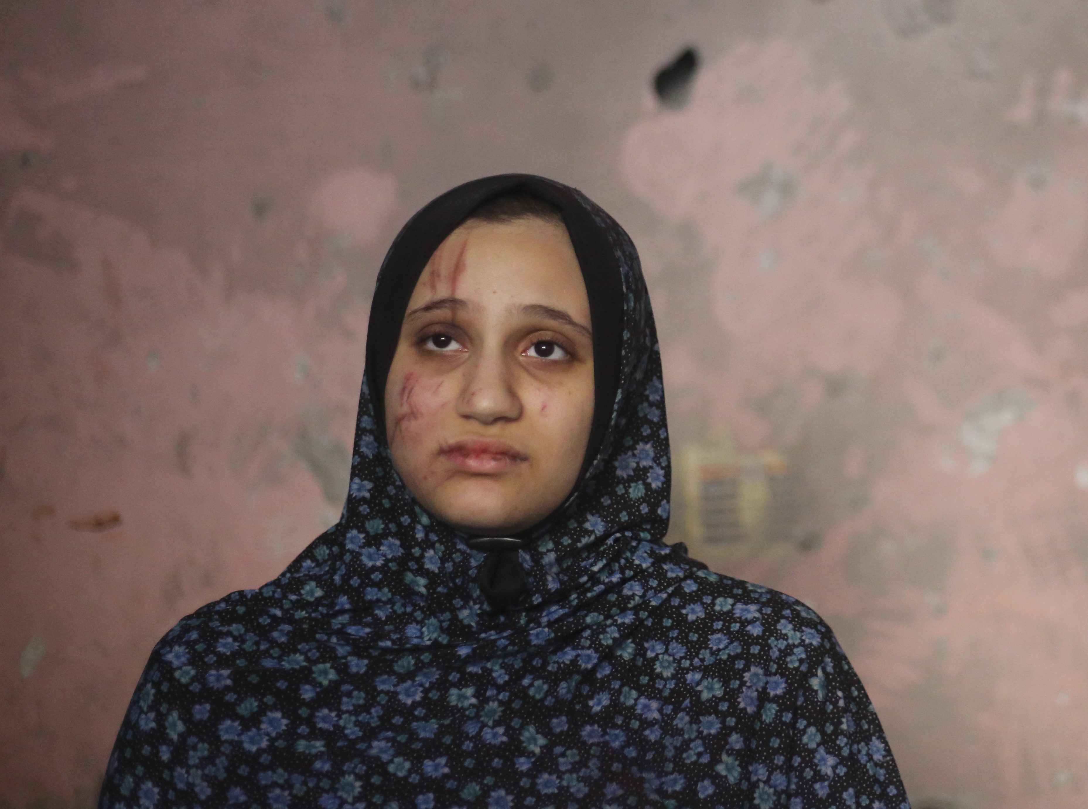 A Palestinian woman stands in her home after an Israeli strike in Rafah