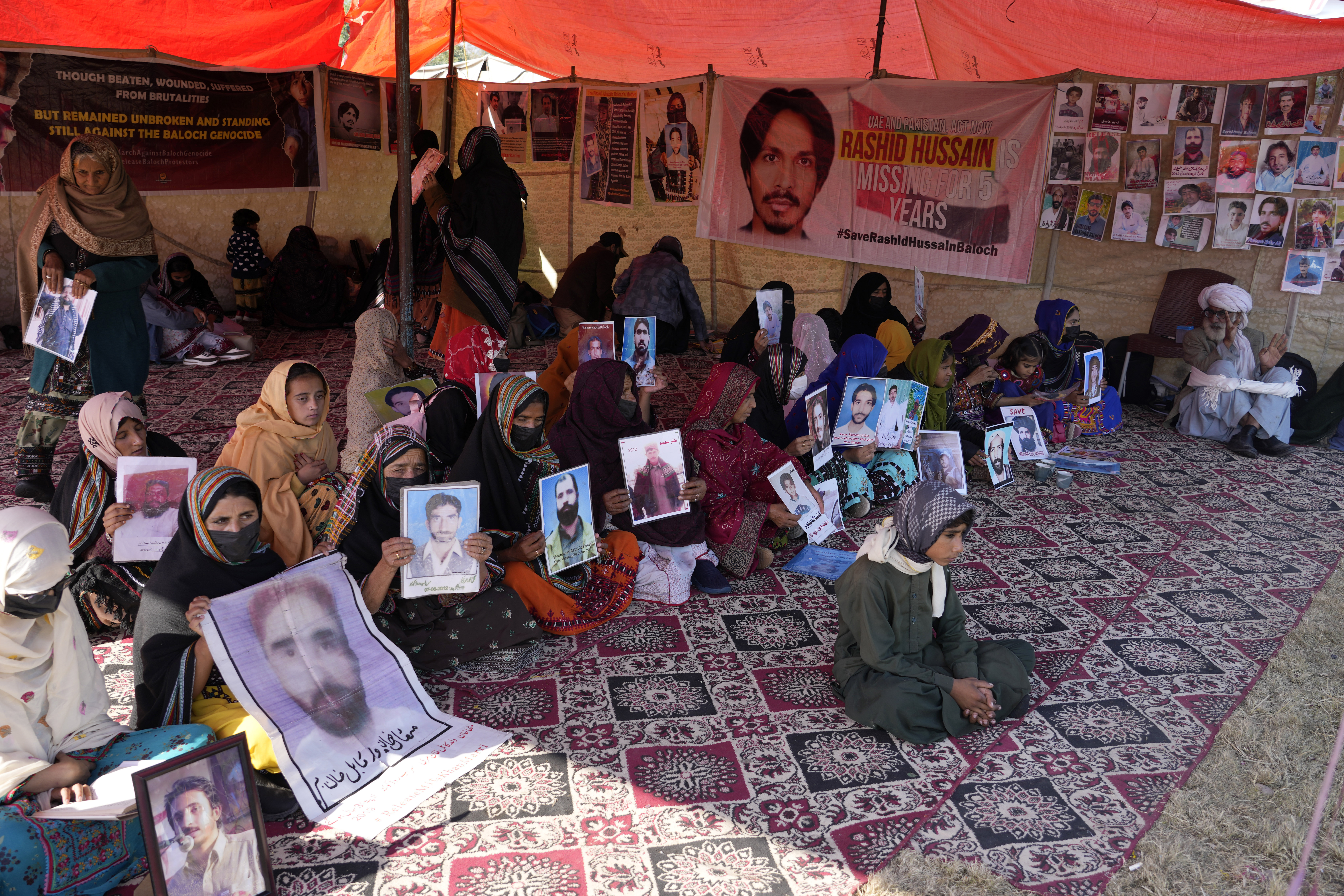 Baloch activists hold portraits of their missing family members during their sit-in protest, in Islamabad, Pakistan Monday, Dec. 25, 2023. Pakistani police say they have freed 290 Baloch activists who were arrested when they attempted to hold a protest rally last week in the capital, Islamabad. Their release Monday came after protest organizers gave authorities a three-day deadline to free all those detained. The activists had travelled from Baluchistan province to protest forced disappearances and extrajudicial killings in the militancy-ravaged southwest. (AP Photo/Anjum Naveed)