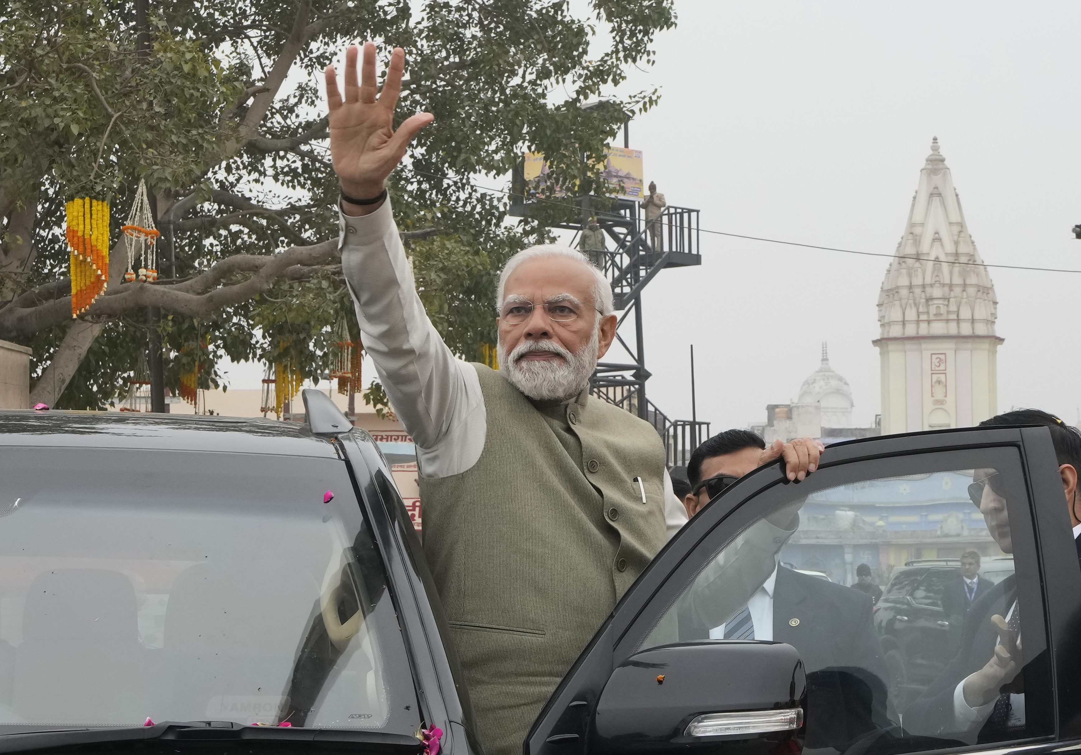 Indian Prime Minister Narendra Modi waves to the crowd during a road show before inaugurating a new airport and a railway station in Ayodhya, India.