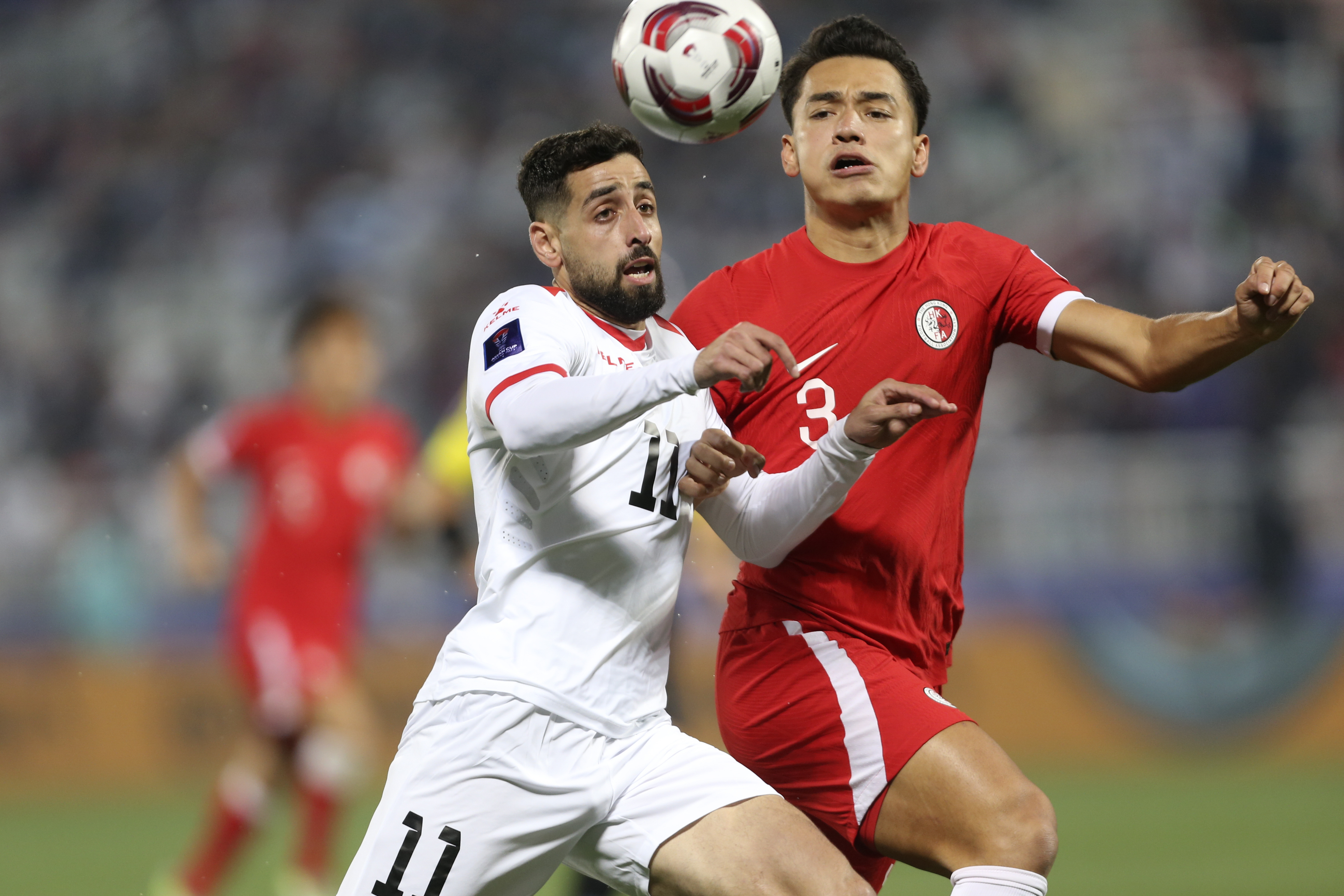 Palestine's Oday Dabbagh, left, fight for the ball against Hong Kong's Oliver Benjamin Gerbig
