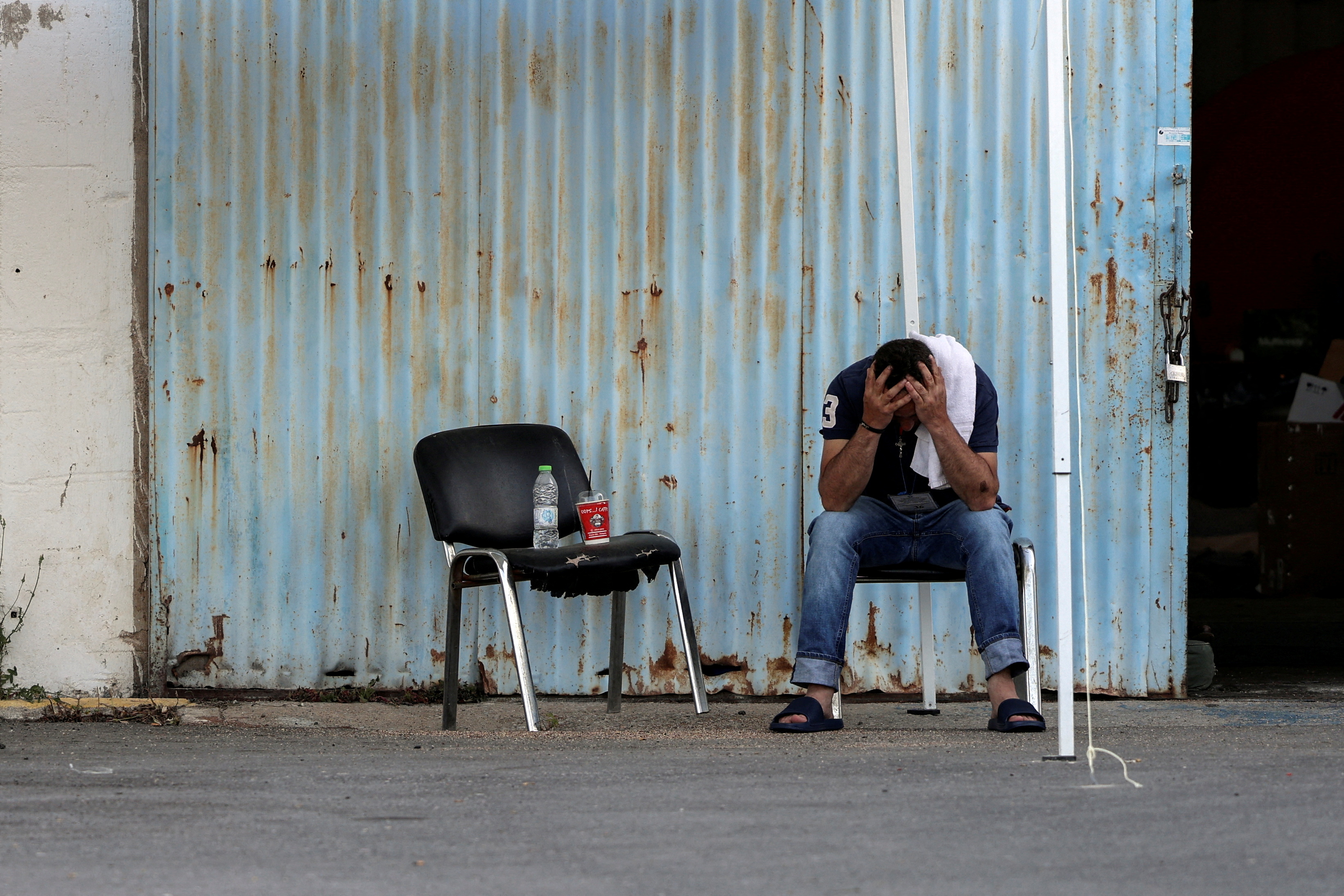 A survivor who was rescued at open sea off Greece along with others, after their boat capsized, reacts outside a warehouse used as a shelter, at the port of Kalamata, Greece, June 15, 2023. REUTERS/Stelios Misinas TPX IMAGES OF THE DAY