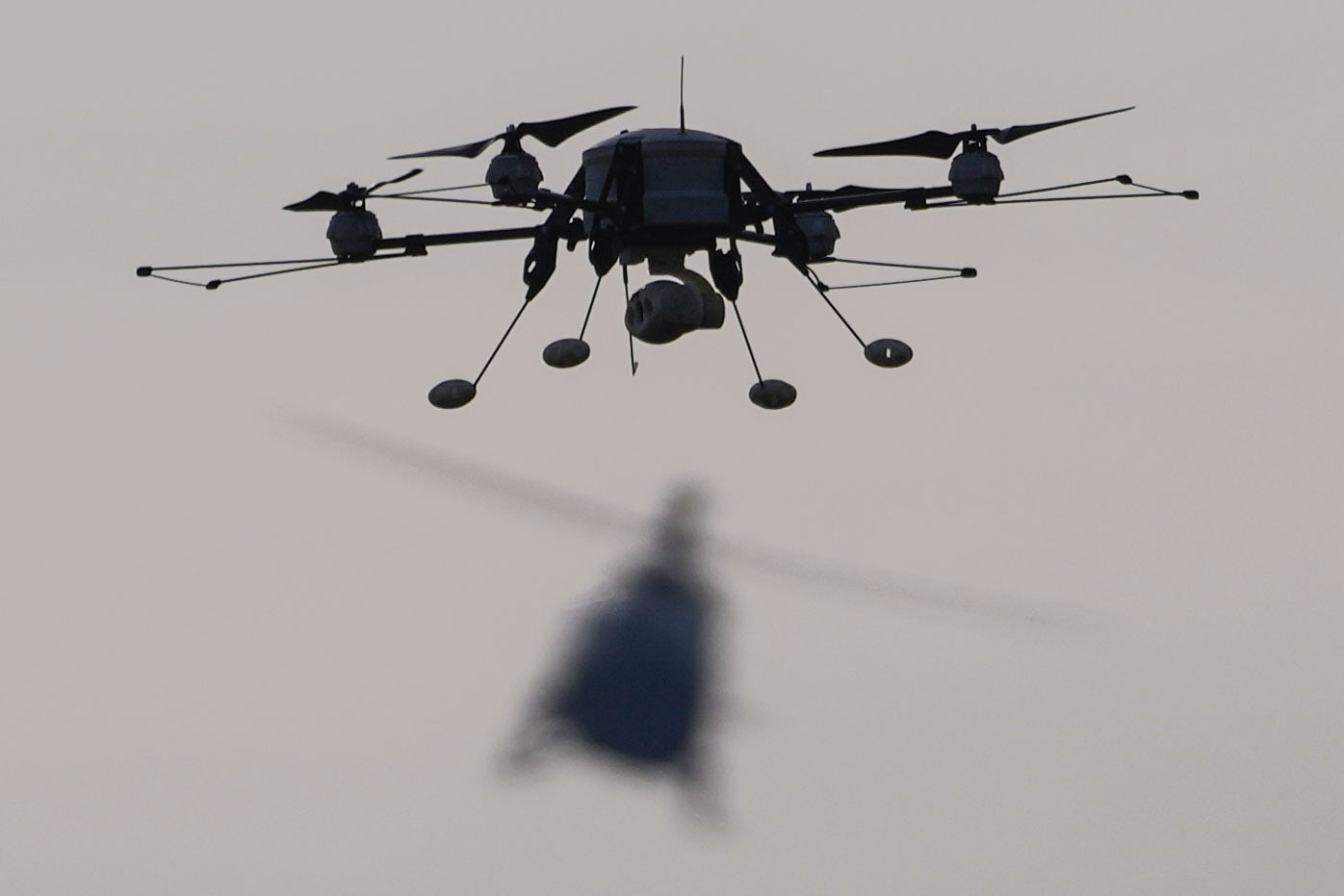 A drone, front, and Serbian Army Airbus H145M multi-utility helicopter fly during the military exercise at the army barracks in Pancevo, some 16 kilometers (10 miles) north of Belgrade, Serbia,