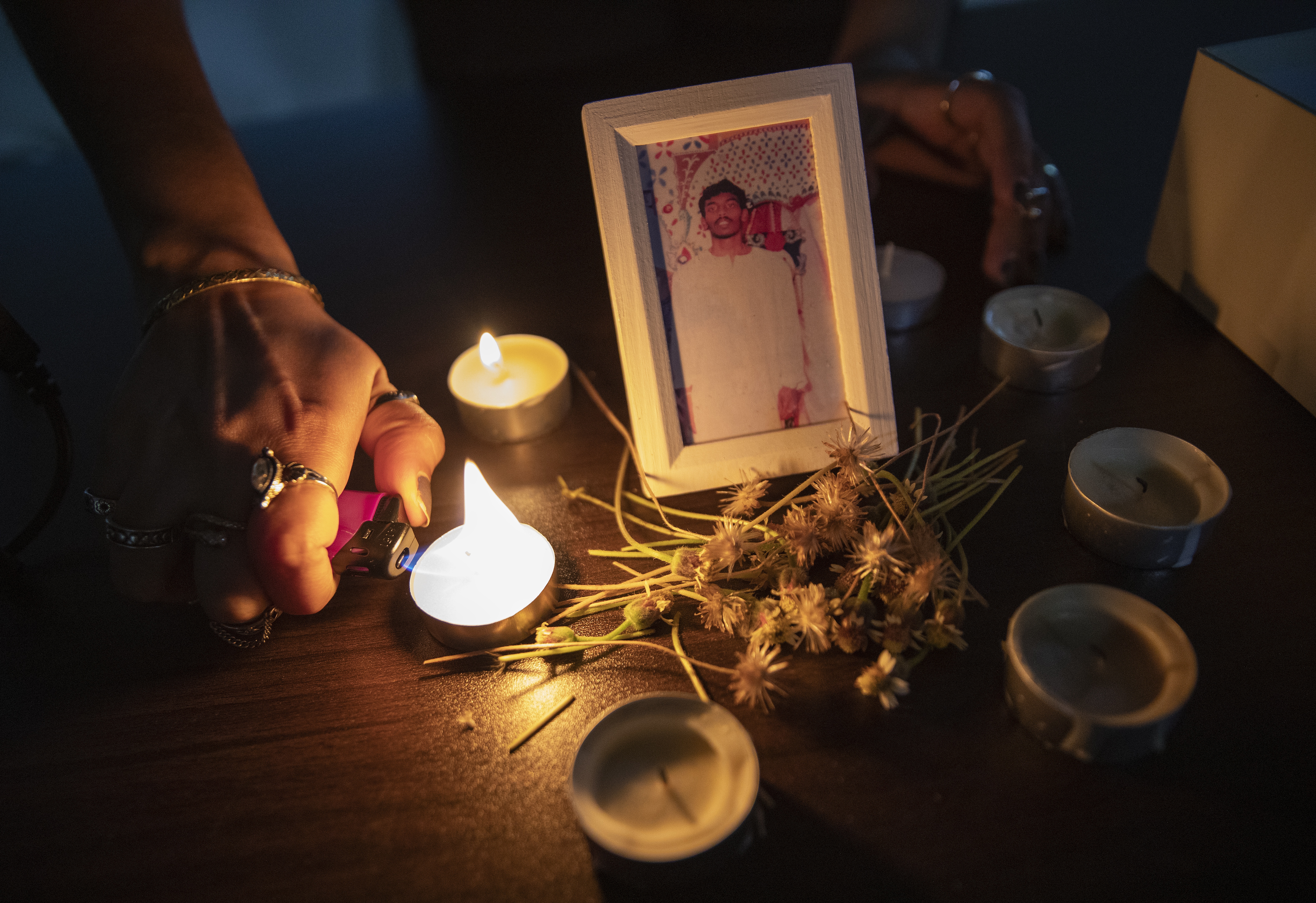 Candles at a vigil for death row inmate Tangaraju Suppiah. There is a picture of him in the middle.