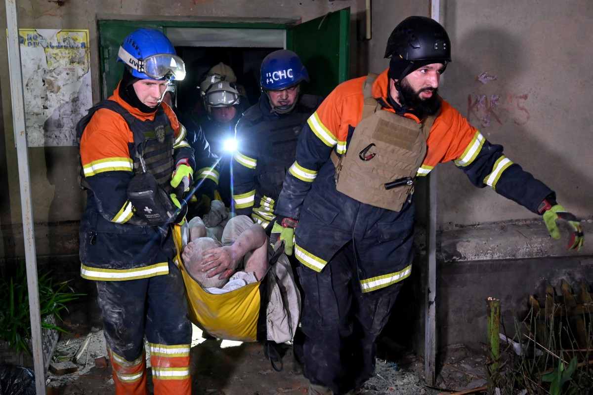 Rescuers carry an injured local resident on a stretcher following a missile attack in Kharkiv