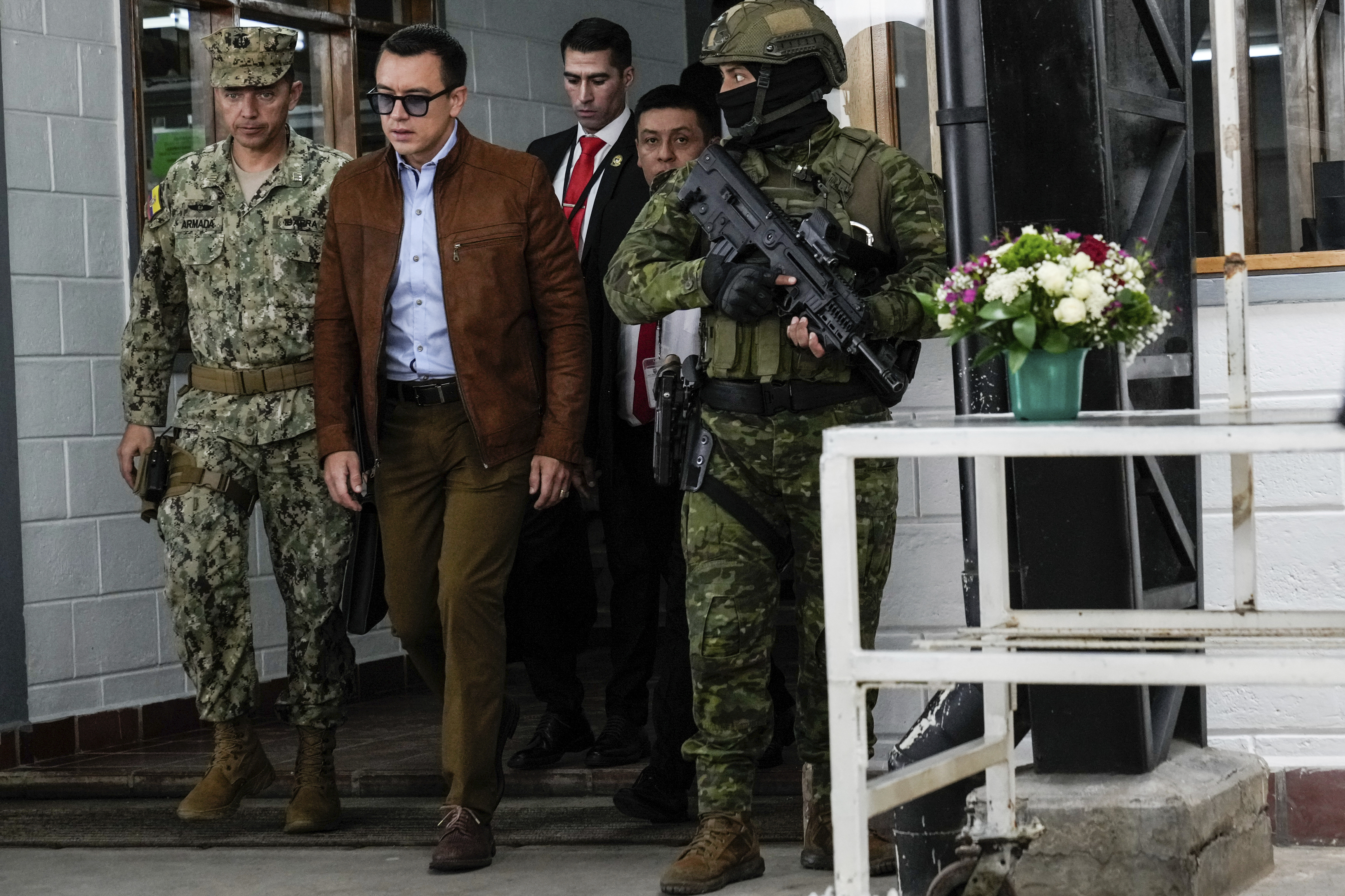 Daniel Noboa walks through a room surrounded by armed security forces.