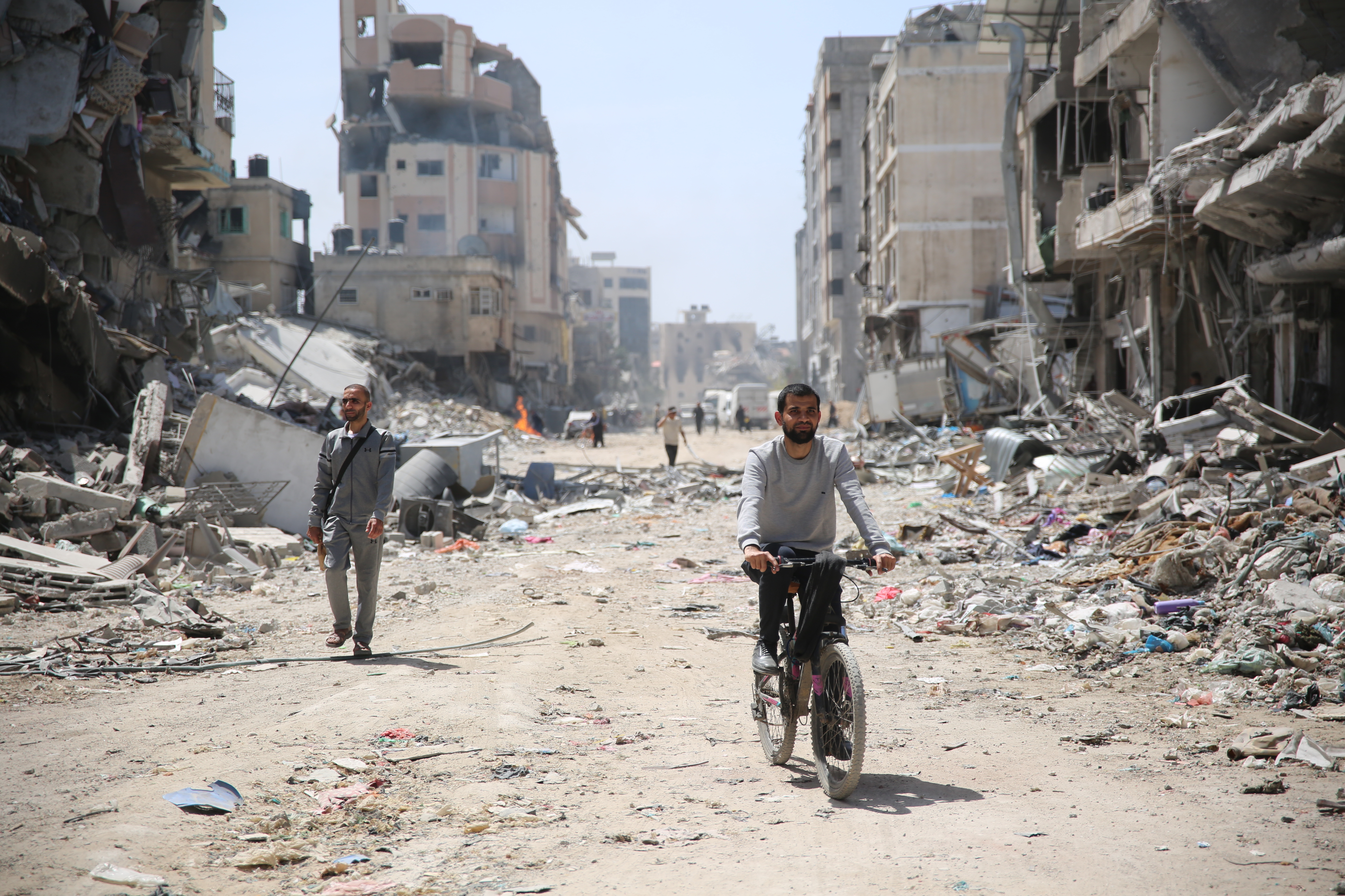 A man rides a bicycle near the debris of damaged building as the area around the Al-Shifa Hospital is destroyed in Gaza City, Gaza on April 01, 2024. The Israeli army said Monday that it wrapped up its military operation at the Al-Shifa Hospital complex in Gaza City, following a 14-day siege and incursion that resulted in scores of casualties and hundreds of arrests.