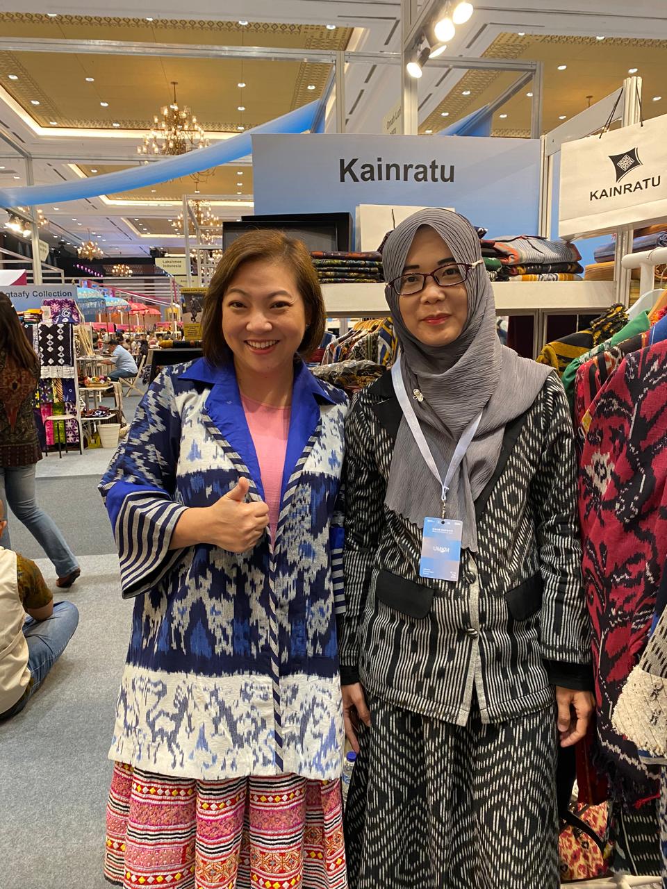 Maria Leoni with a Chinese friend. She is wearing a black and silver woven outfit with a grey headscarf,