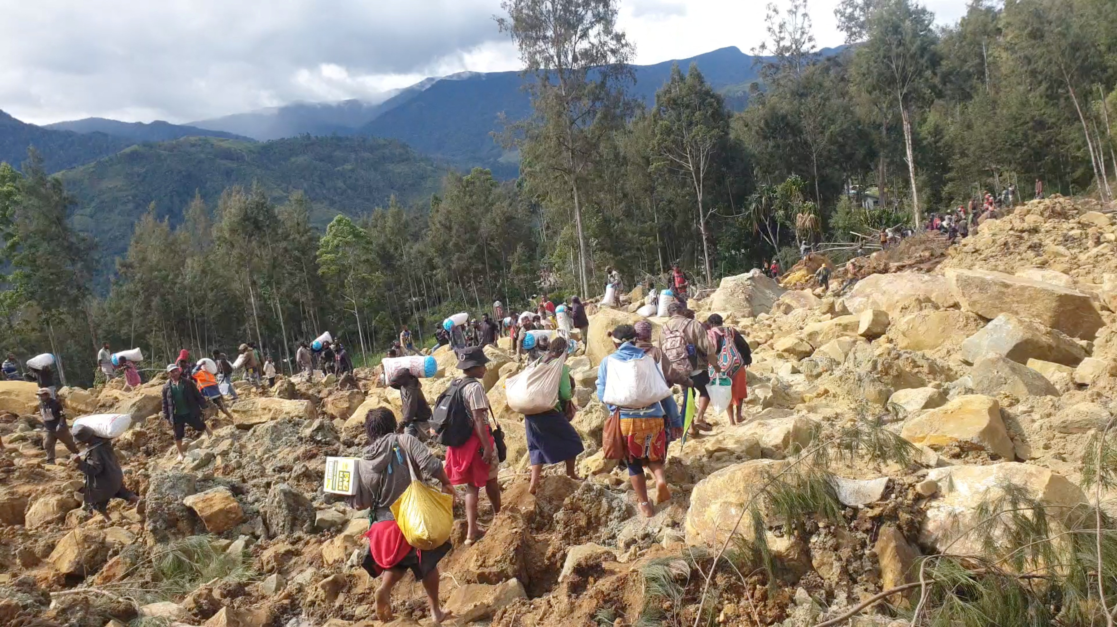 Residents carry their bags in the aftermath of a deadly landslide in Enga province of Papua New Guinea