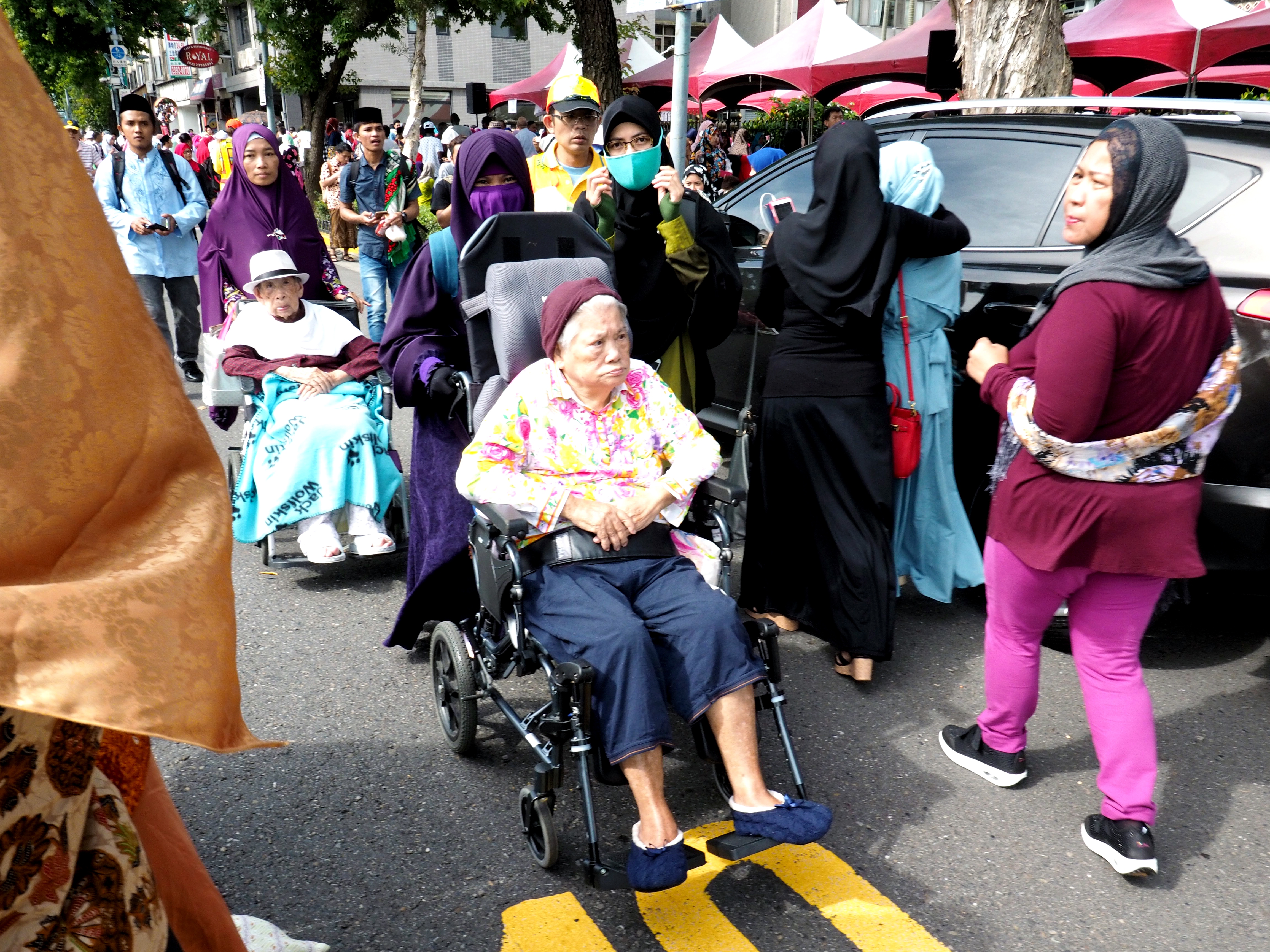 Indonesian domestic workers with the elderly people they care for in Taiwan.
