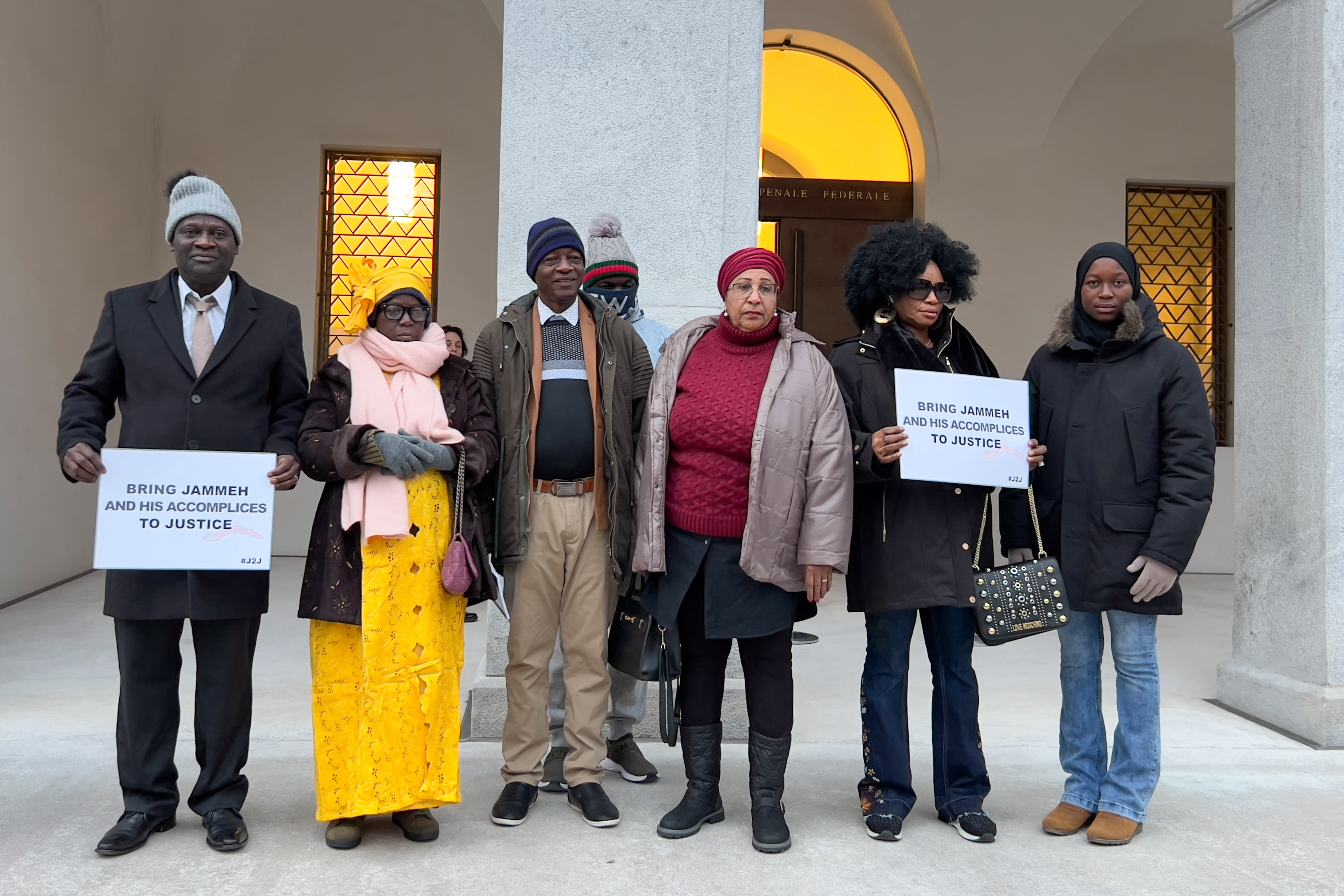 Plaintiffs pose at the entrance of the Swiss Federal Criminal Court, on January 8, 2024 in Bellinzona, southern Switzerland at the opening day of the trial of Ousman Sonko, a Gambian former interior minister accused of crimes against humanity committed under the regime of ex-dictator Yahya Jammeh