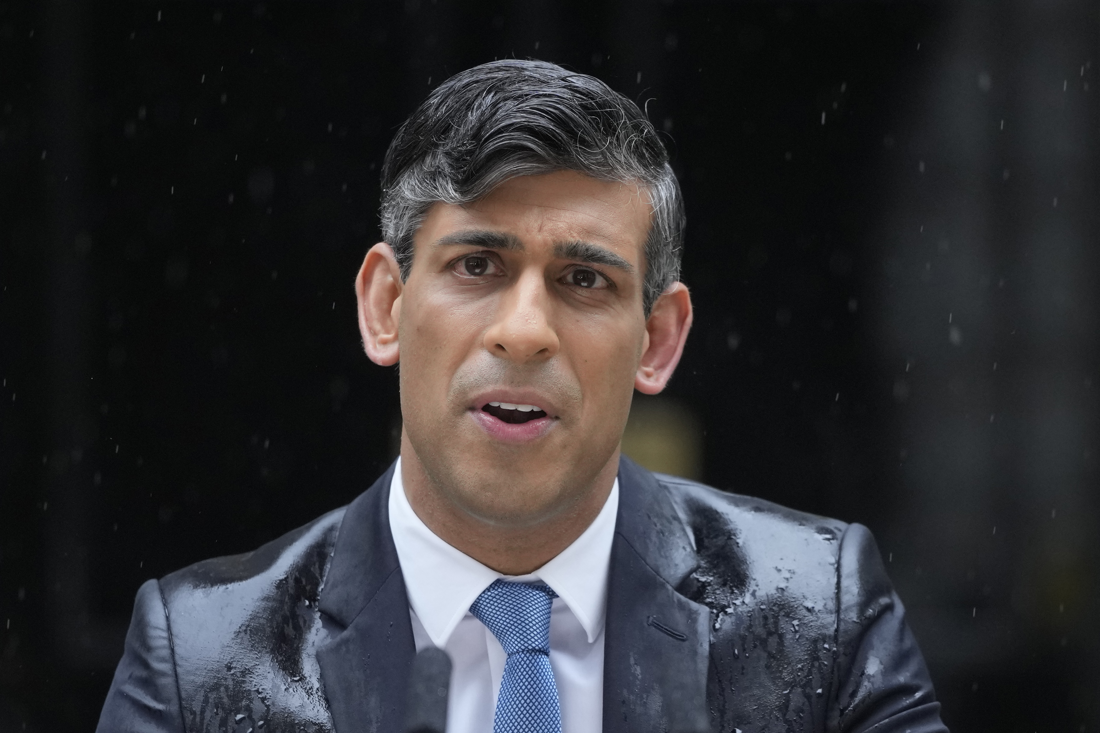 Britain's Prime Minister Rishi Sunak speaks to the media, as heavy rain falls, outside 10 Downing Street in London Wednesday,