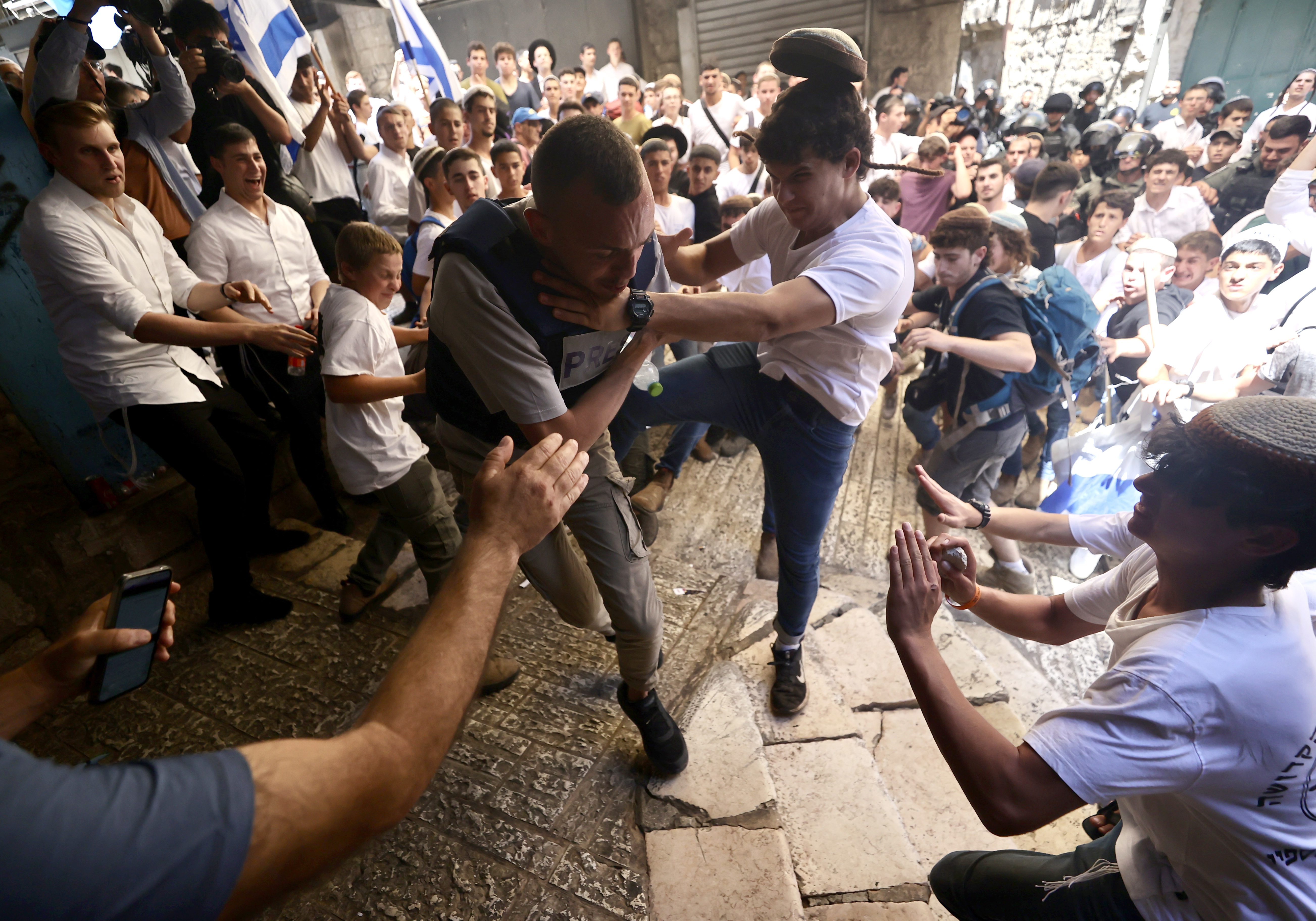 JERUSALEM - JUNE 05: A man attacks a press member as hundreds of fanatical Jews raid the Old City under police protection in East Jerusalem on June 5, 2024. Far-right fanatic Jews organize "flag marches" every year according to the Hebrew calendar. During their march, far-right fanatic Jews arrived to the Damascus Gate in the Old City area. ( Mostafa Alkharouf - Anadolu Agency )