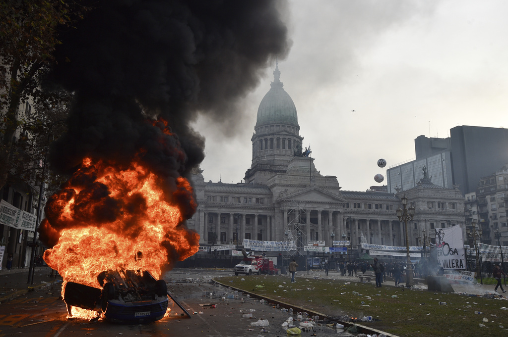 A car burns during clashes between police and anti-government protesters outside Argentina's Congress