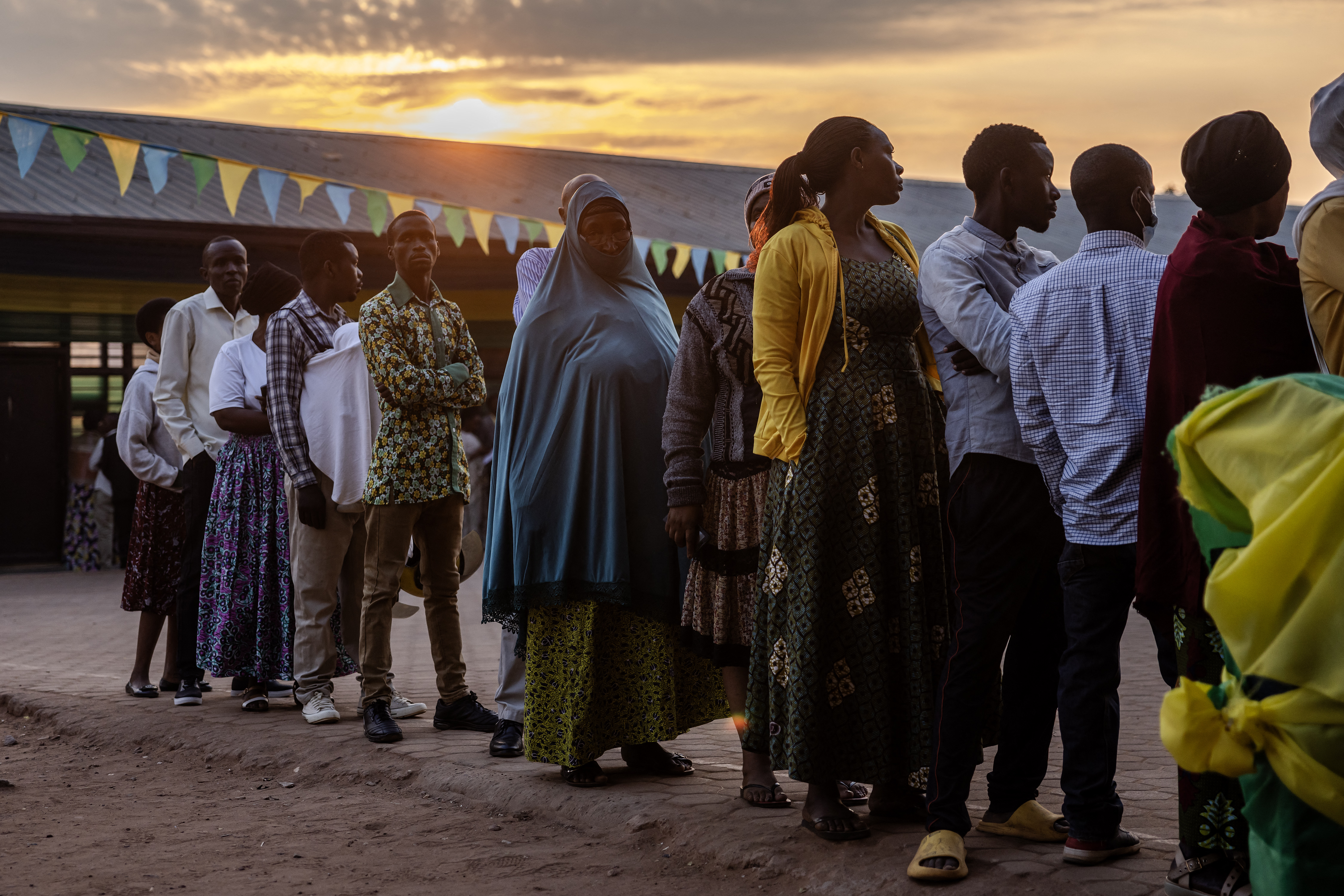 Voters queue to cast their ballot early in the morning before the opening of the polls during the 2024 Rwandan general elections at a polling station in Kigali, on July 15, 2024. - Millions of Rwandans head to the polls on July 15, 2024 with veteran President Paul Kagame set to cruise to an easy victory over his two approved challengers and extend his iron-fisted rule for another five years. (Photo by LUIS TATO / AFP)
