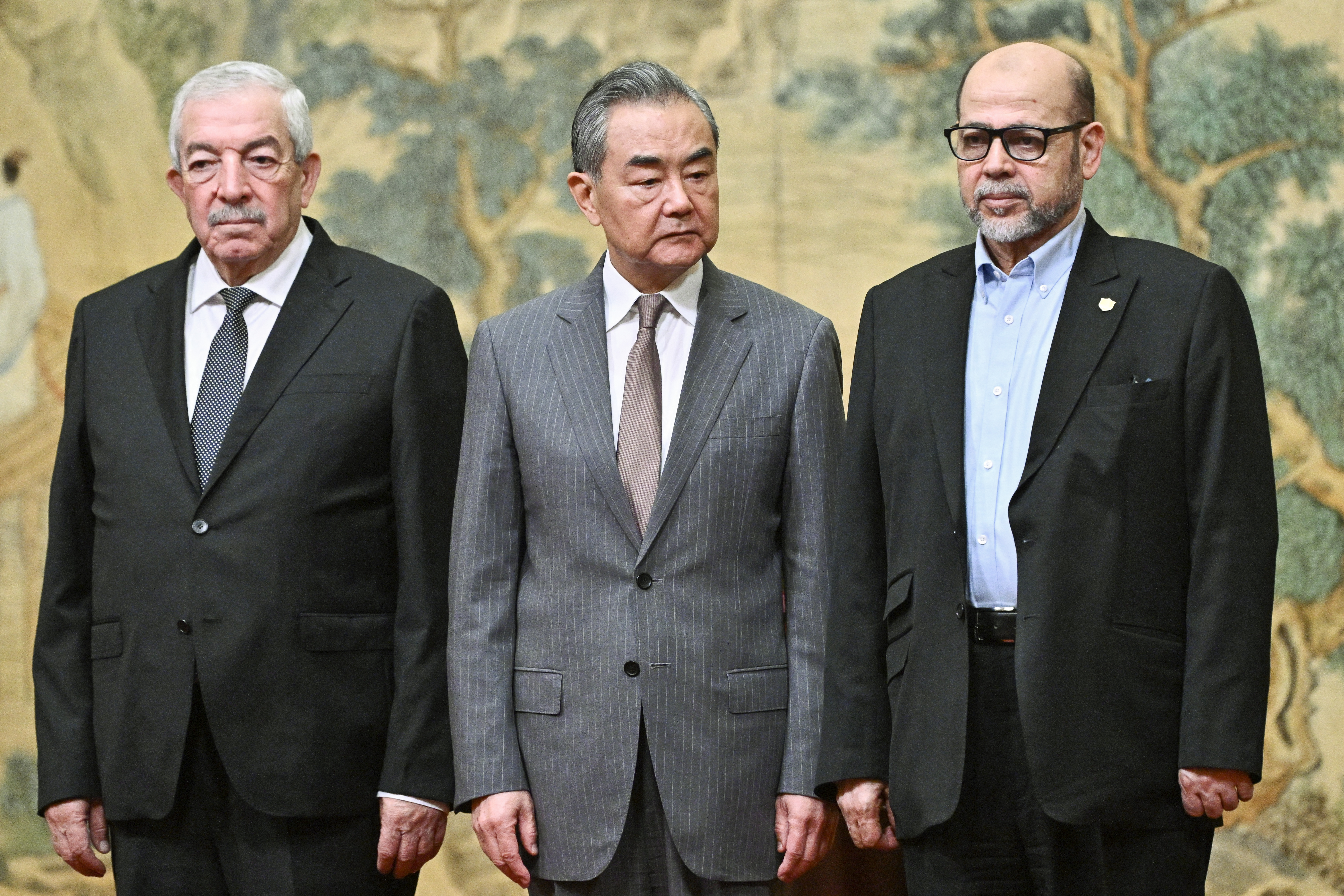 (L-R) Mahmoud al-Aloul, Vice Chairman of the Central Committee of Palestinian organization and political party Fatah, China's Foreign Minister Wang Yi, and Mussa Abu Marzuk, senior member of the Palestinian Islamist movement Hamas, attend an event at the Diaoyutai State Guesthouse in Beijing on July 23, 2024. - China's Foreign Minister Wang Yi on July 23 hailed an agreement by 14 Palestinian factions to set up an "interim national reconciliation government" to govern Gaza after the war. (Photo by Pedro Pardo / AFP)