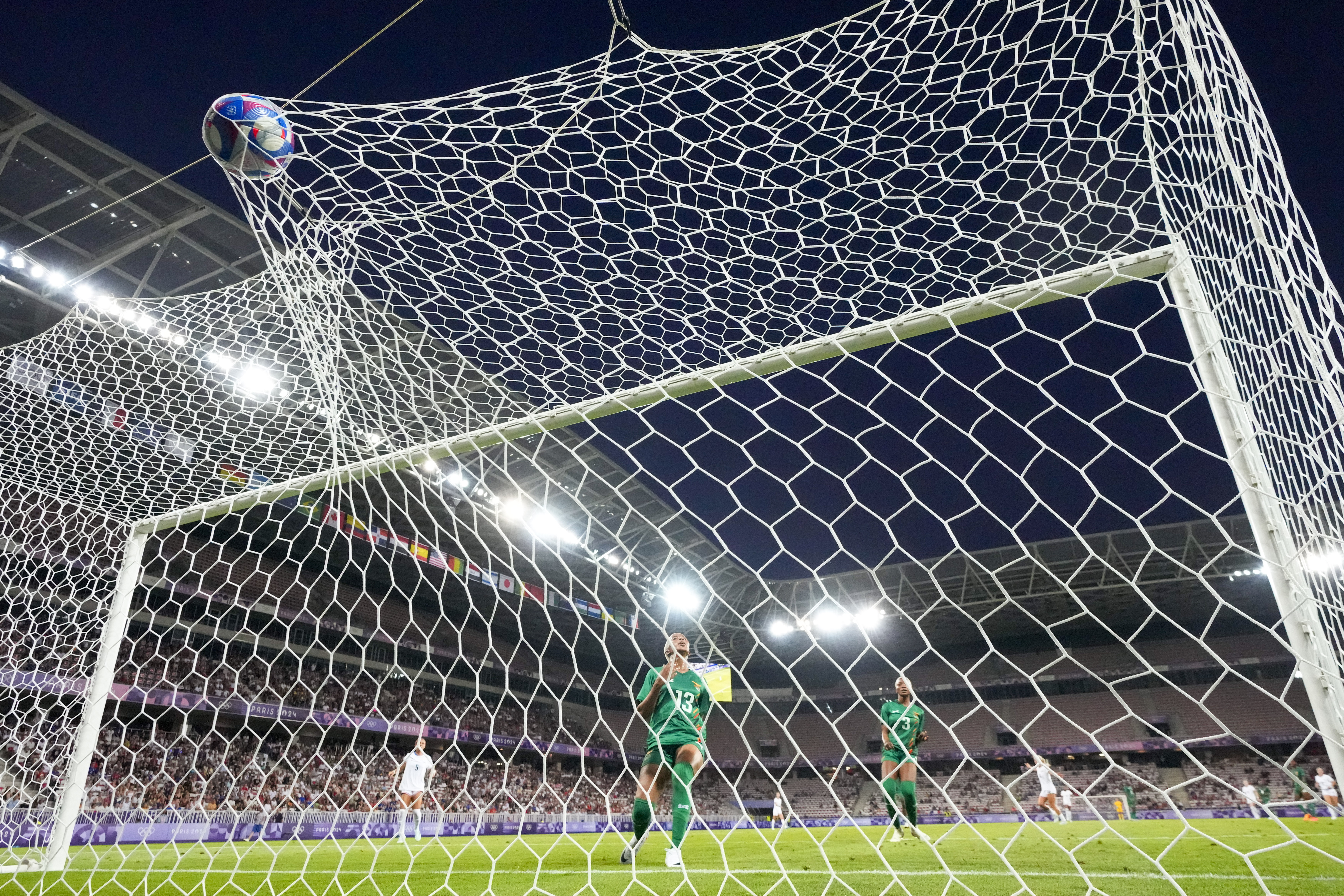 Zambia's Martha Tembo (13) and Lushomo Mweemba (3) look on as a shot by United States' Mallory Swanson, not visible, enters their net for the United States' second goal during a women's group B match between the United States and Zambia at Nice Stadium at the 2024 Summer Olympics, Thursday, July 25, 2024, in Nice, France. (AP Photo/Julio Cortez)