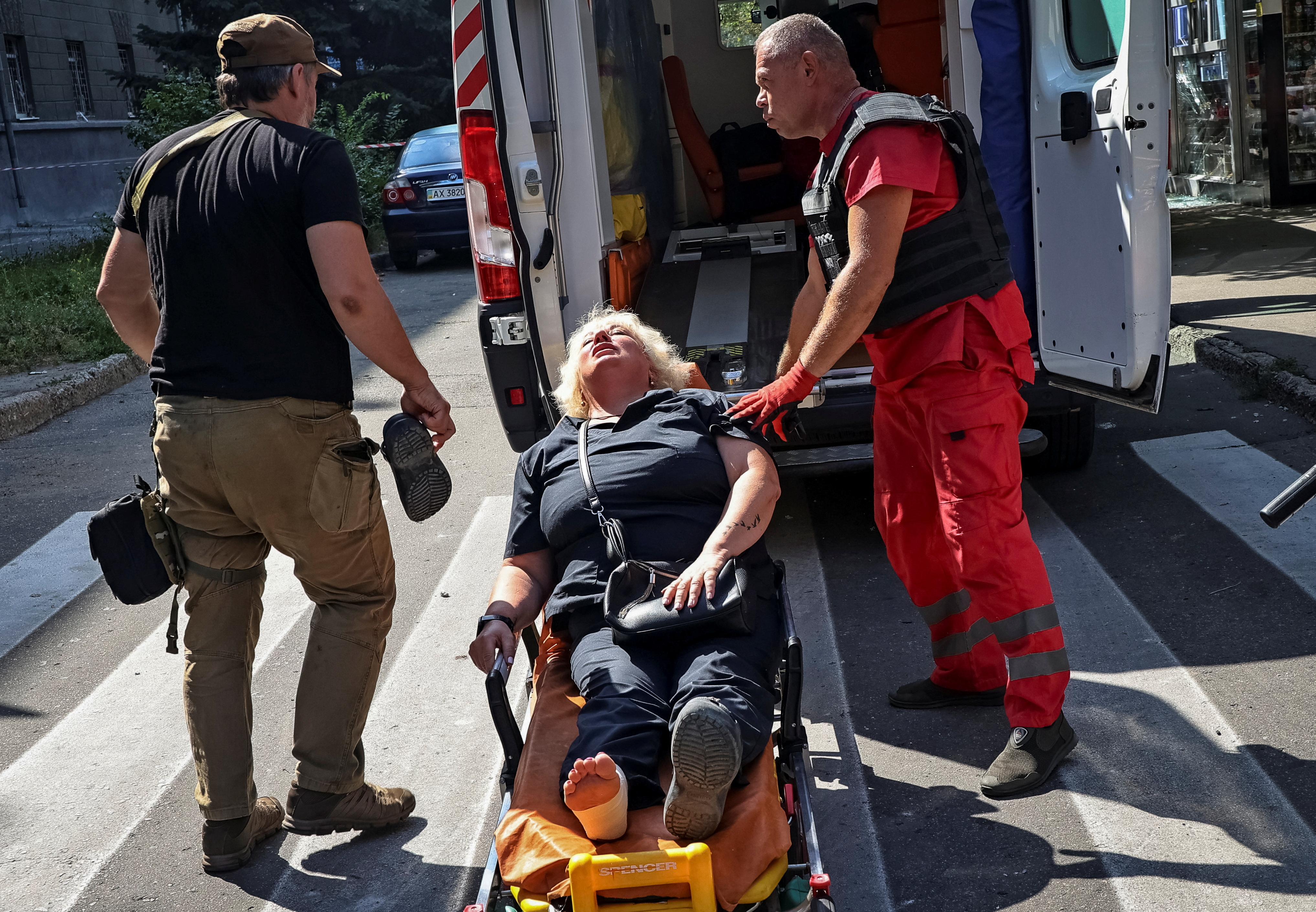 A medical worker treats a wounded local resident at the site of a Russian missile strike, amid Russia's attack on Ukraine, in Kharkiv, Ukraine August 6, 2024. REUTERS/Vyacheslav Madiyevskyy
