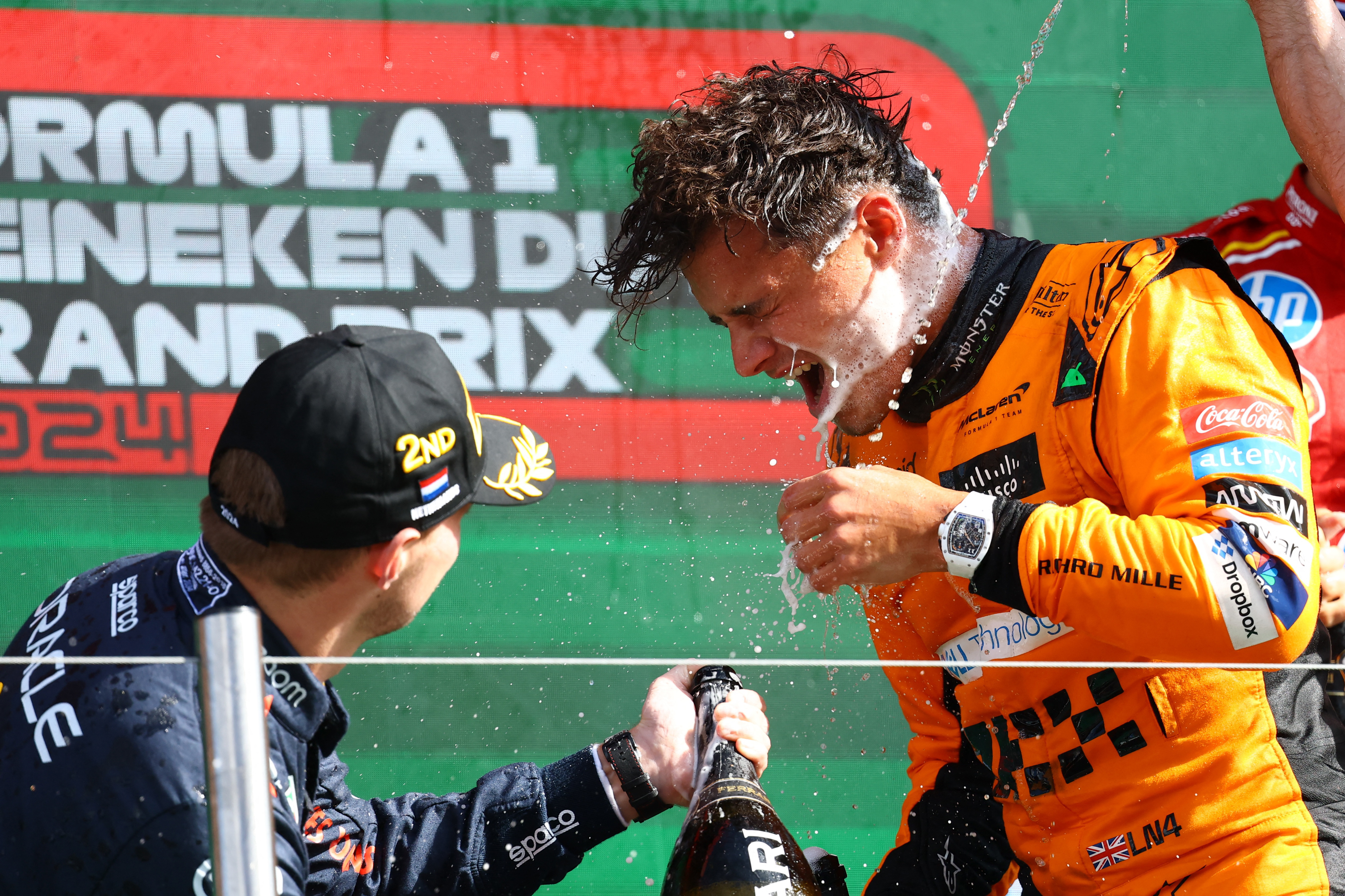 McLaren&#039;s Lando Norris (R) celebrates with champagne on the podium after winning the Dutch Grand Prix with second placed Red Bull&#039;s Max Verstappen [Lisi Niesner/Reuters]