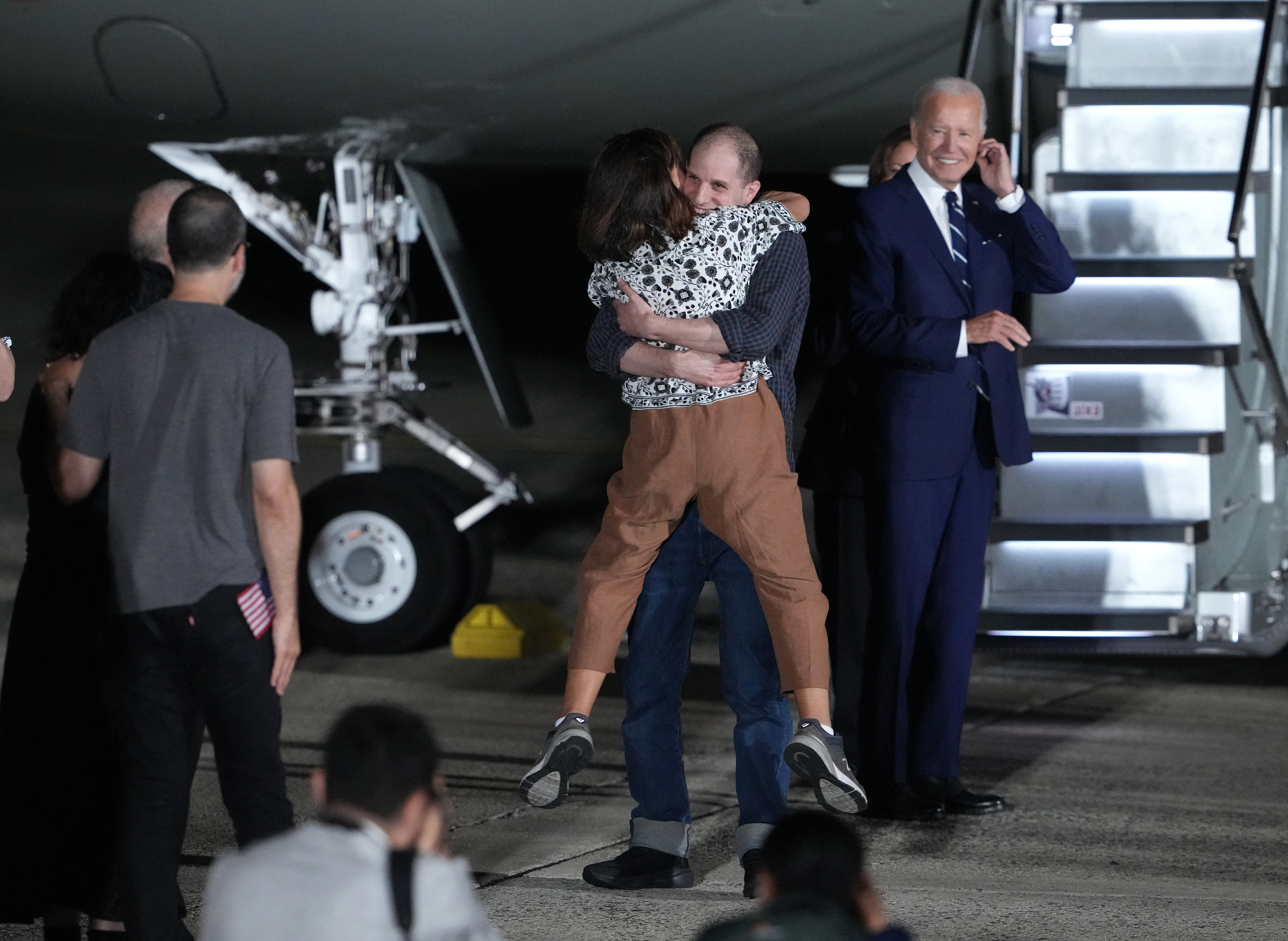 Evan Gershkovich hugging his mum after landing back in the US. They are standing at the bottom of the plane's steps. He has lifted his mum off the ground.